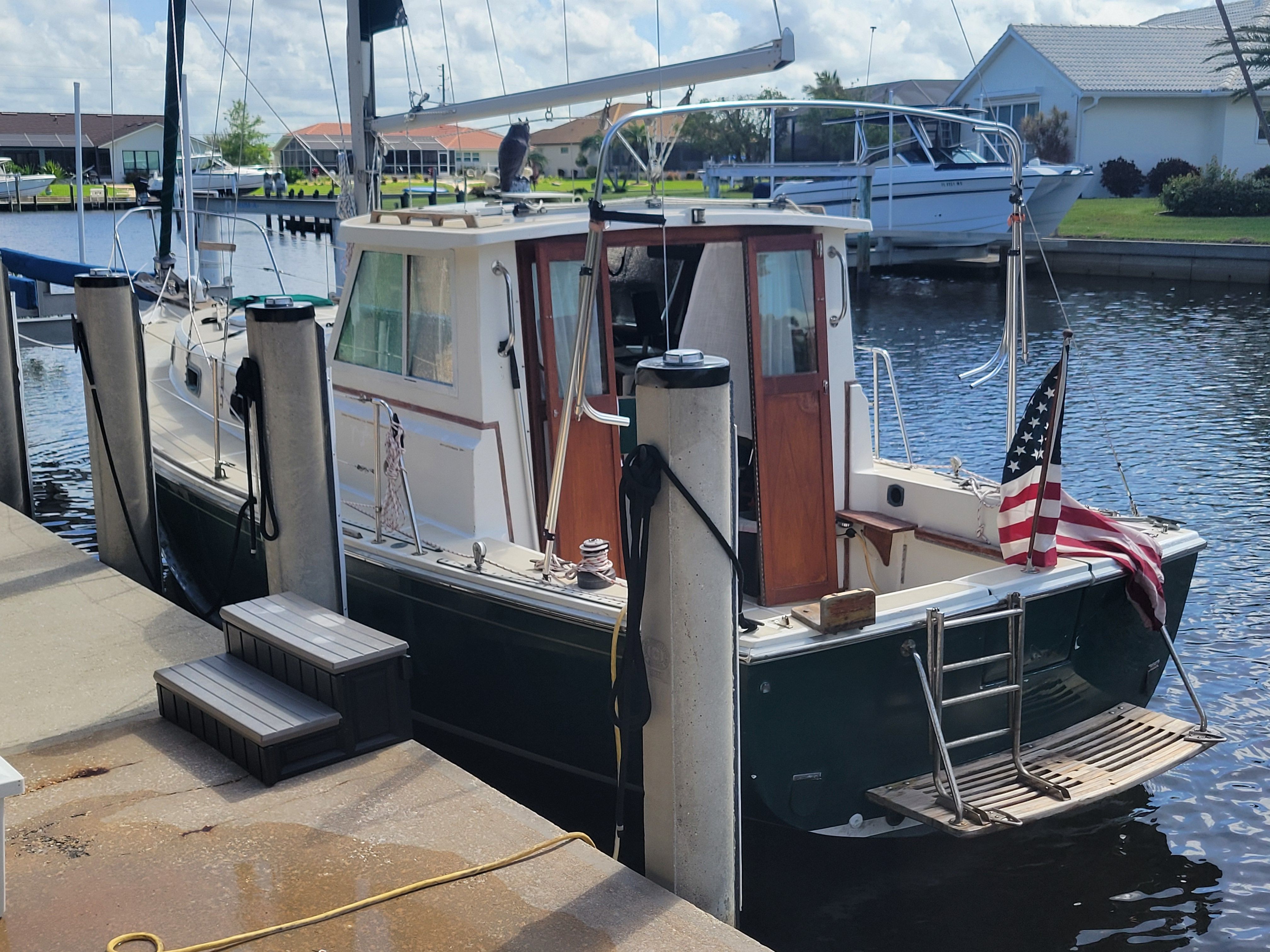 1989 Cape Dory MS300 docked, featuring an American flag and wooden details.