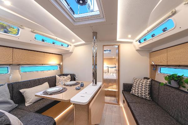 Interior of 2025 Hanse 360 yacht, featuring modern seating, dining area, and natural light.