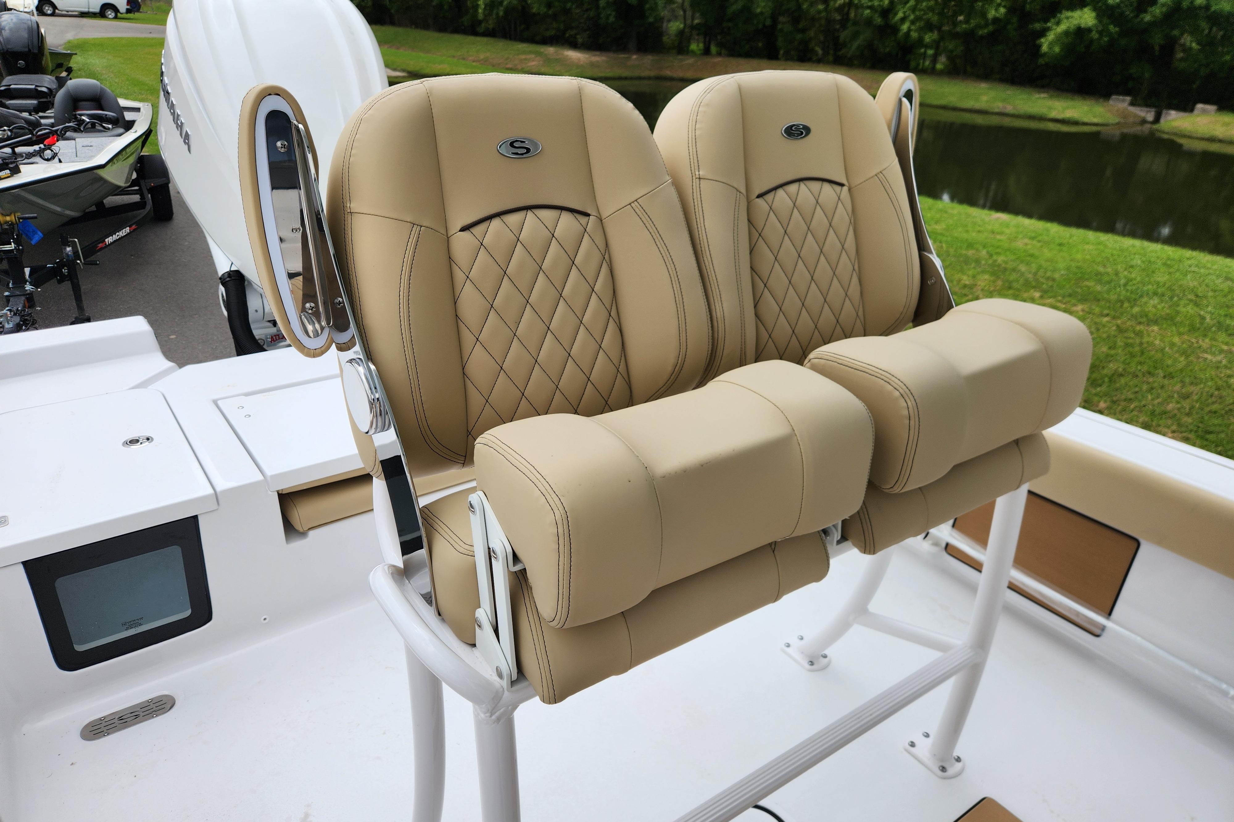 2026 Sportsman Masters 247 Bay Boat with tan cushioned seats, docked near a lake.