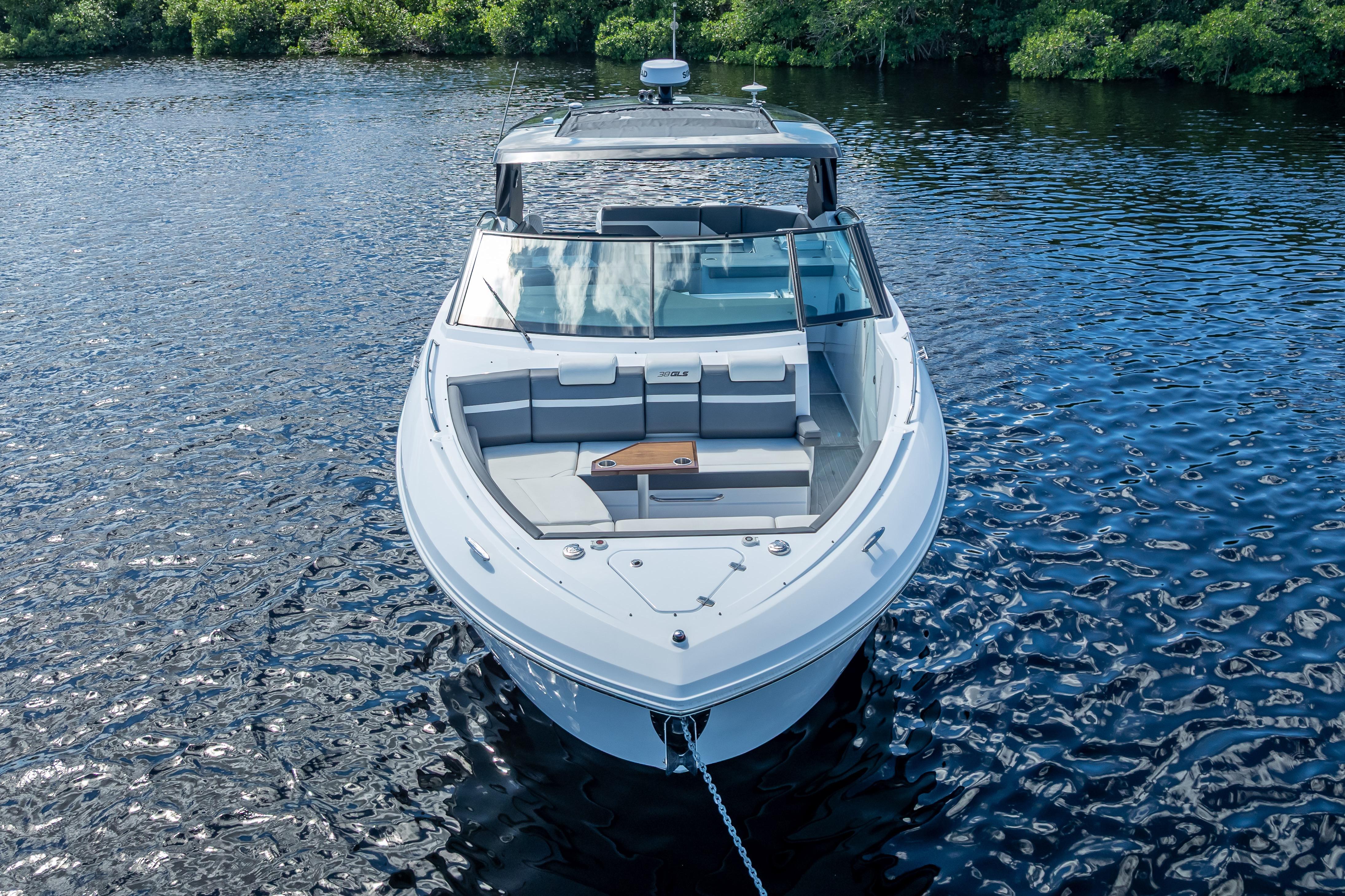 2022 Cruisers Yachts 38 GLS OB on serene water, showcasing sleek design and spacious deck.