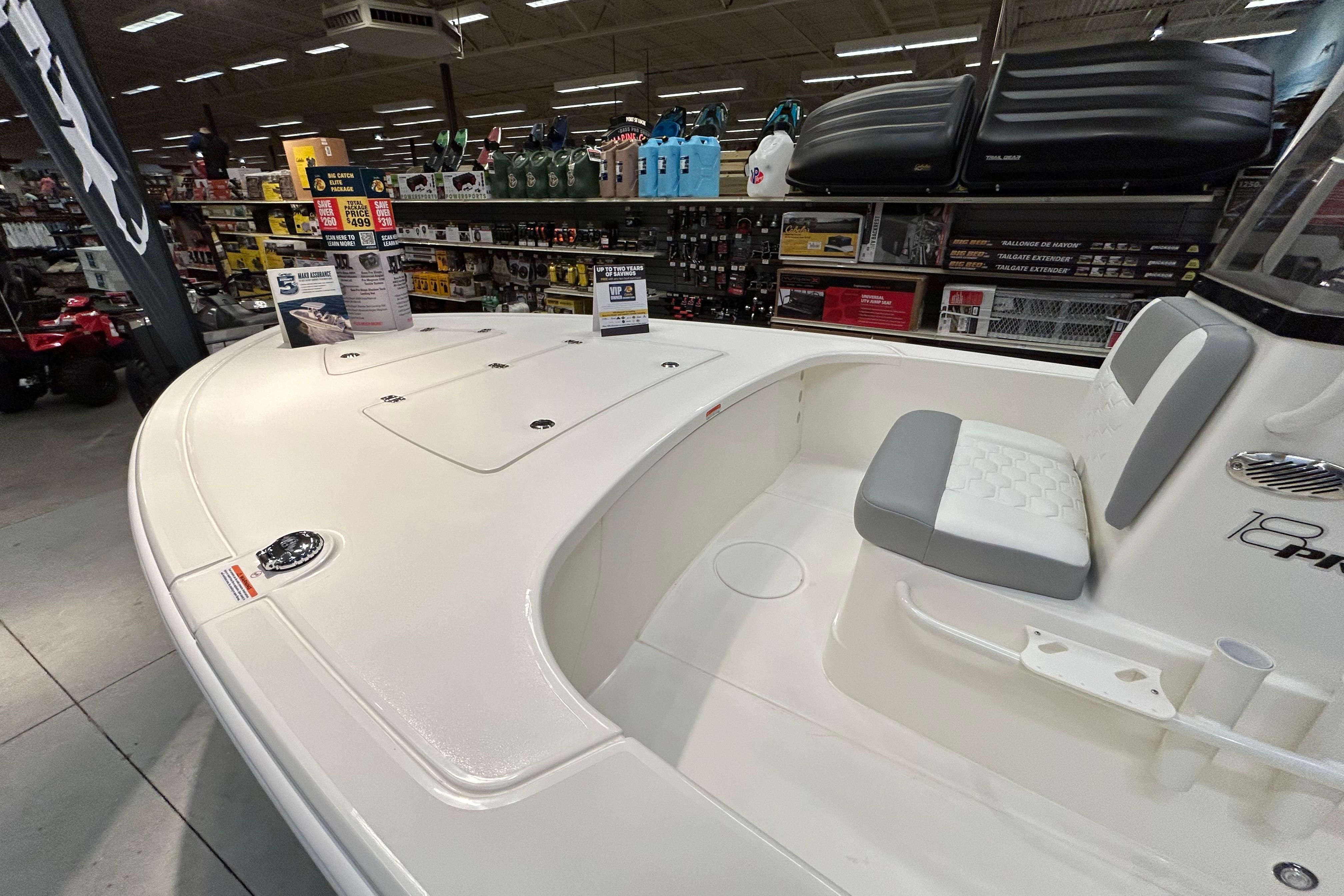 2026 Mako 18 Pro Skiff boat displayed in a showroom with accessories.
