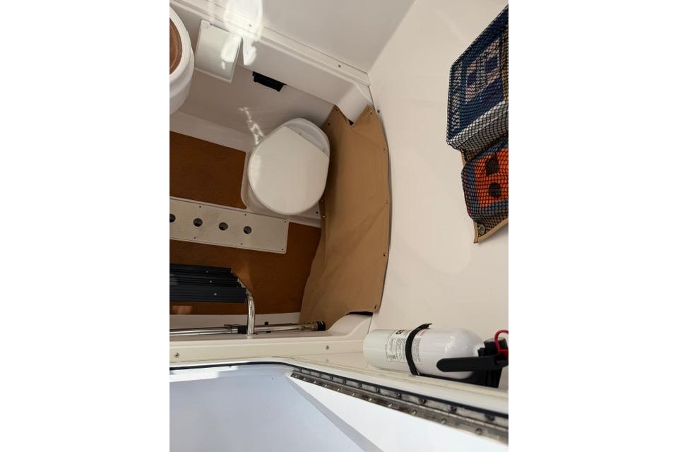 Interior of 2014 Southport 29 FE boat featuring a compact marine toilet.