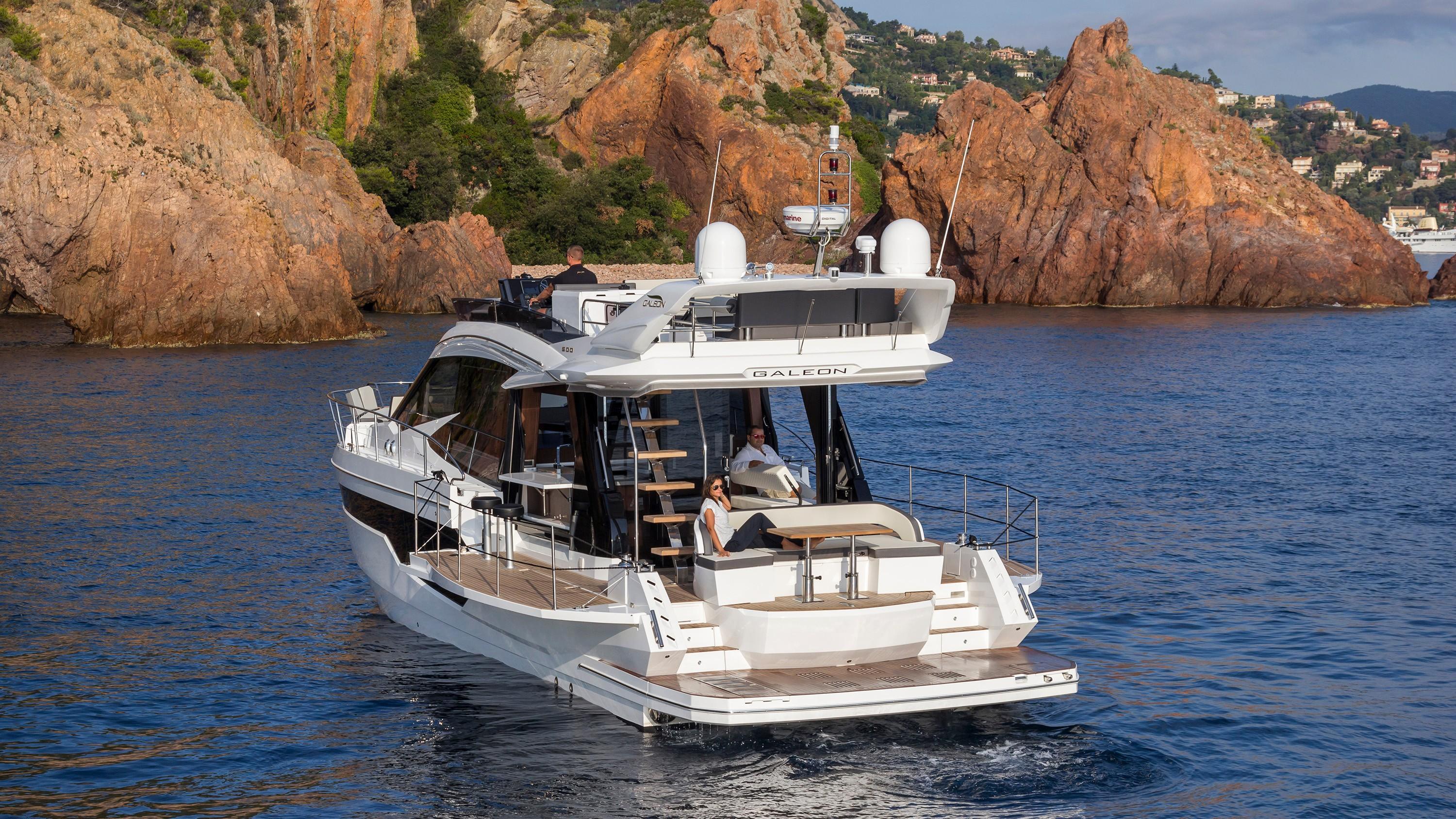 2019 Galeon 500 Fly yacht near rocky coastline.