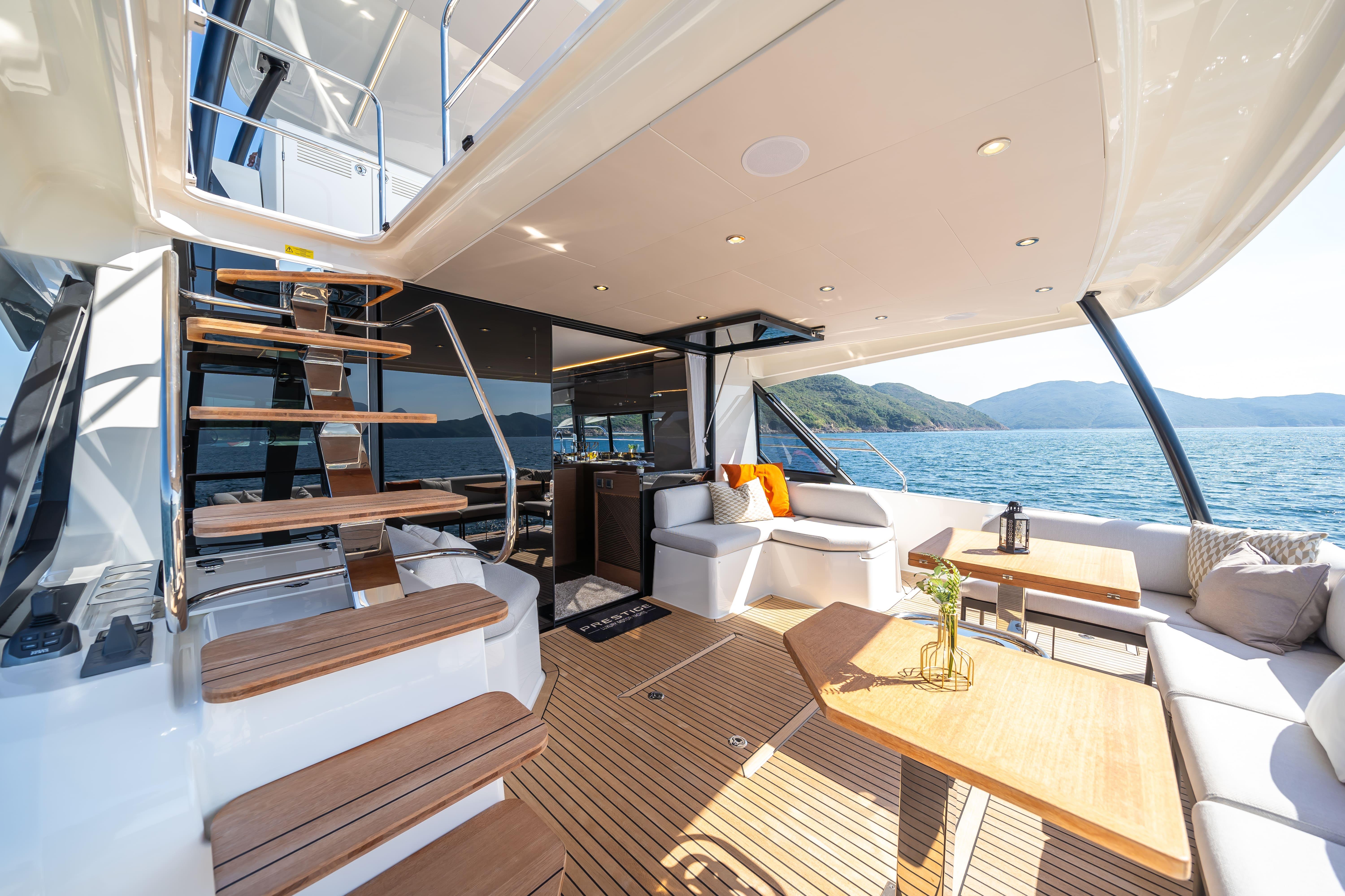Luxurious Prestige M48 yacht interior with wooden deck, modern seating, and scenic ocean view, 2025 model.