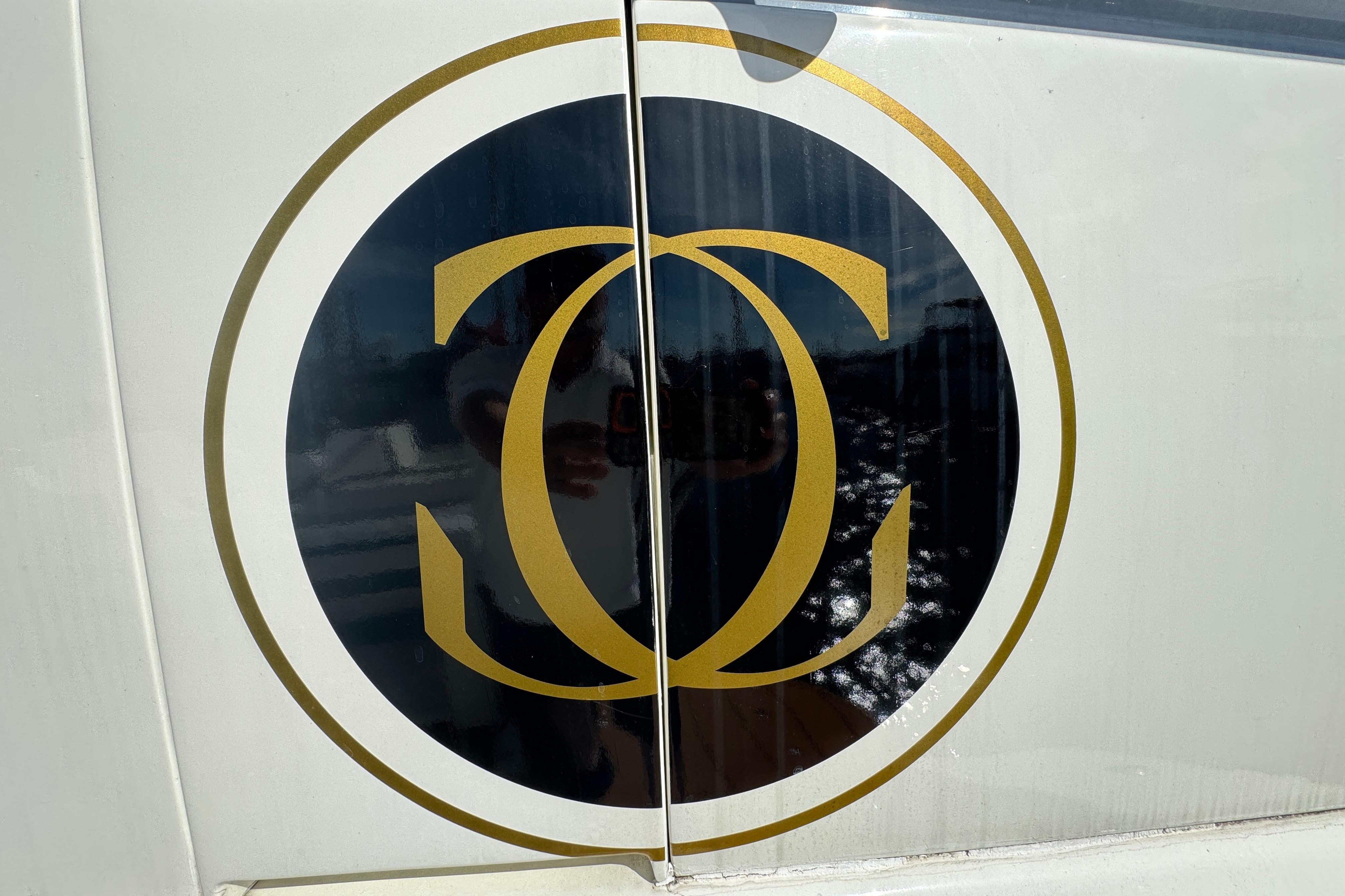 Logo on a 1994 Johnson High-Tech 65 Euro yacht, featuring interlocking gold letters.
