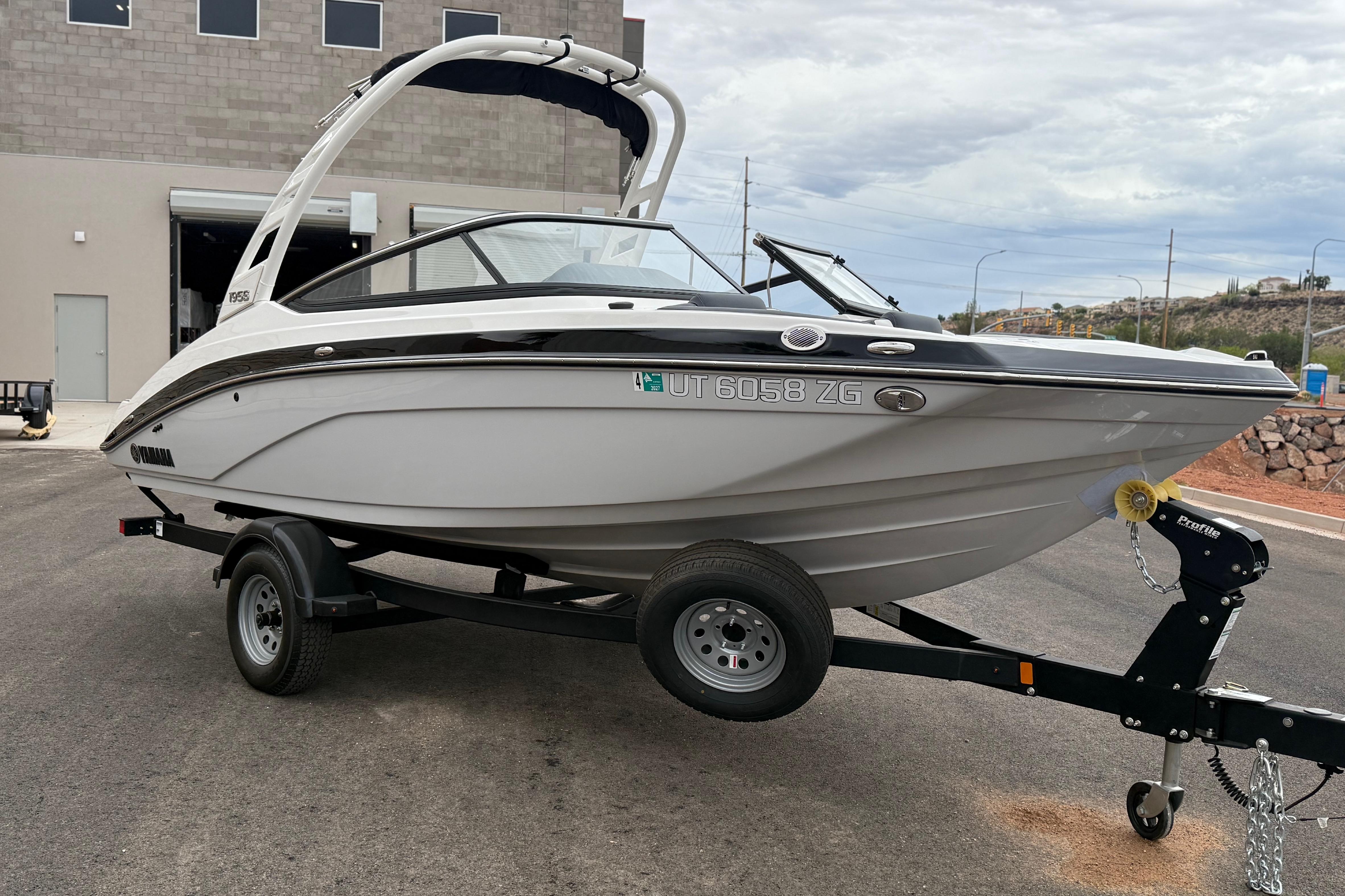 2025 Yamaha Boats 195S on trailer, parked outdoors near industrial building.