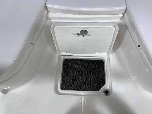 2026 Robalo 226 Cayman boat storage compartment with black mat and secure latch.