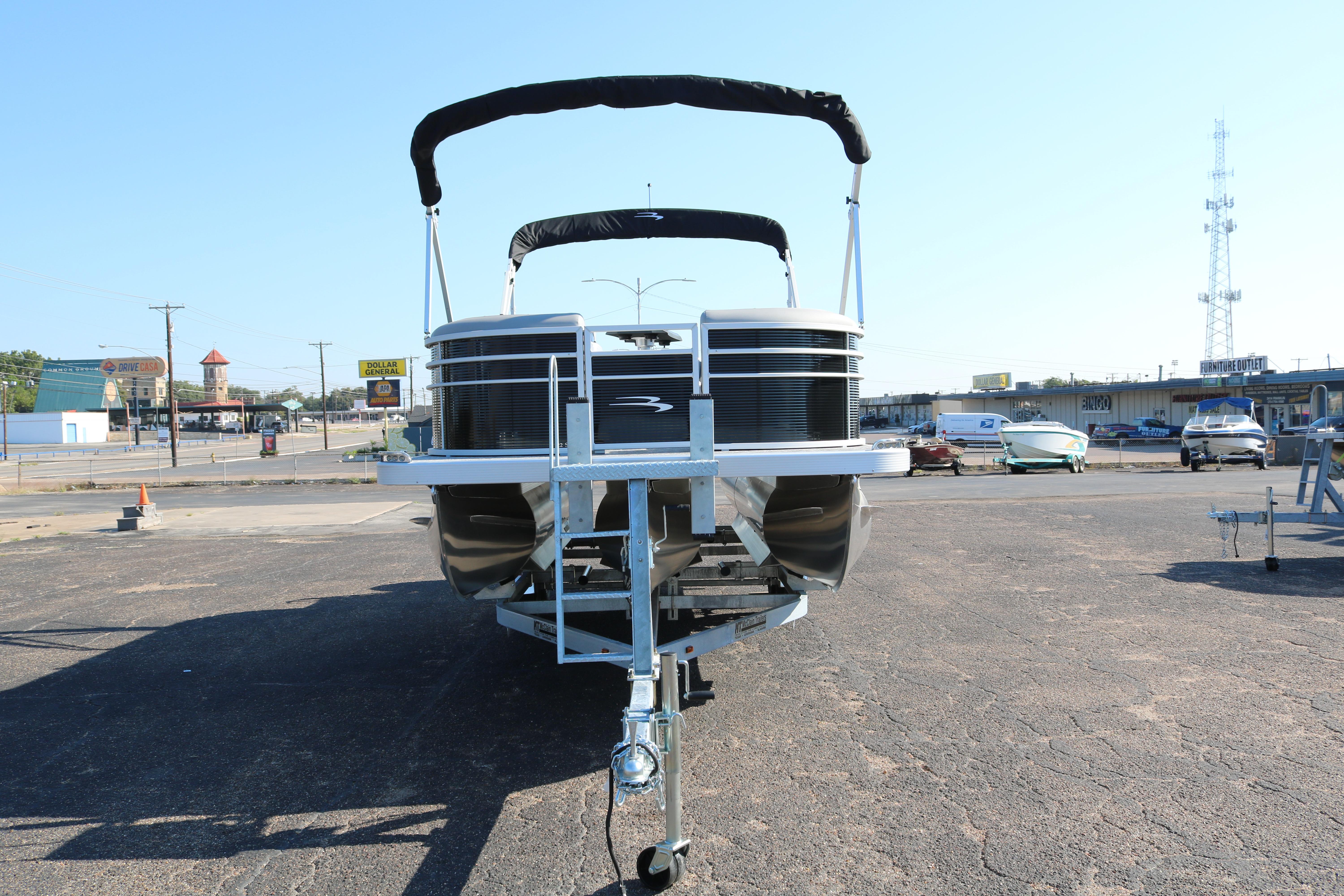 2026 Bennington 22SX Stern Radius pontoon boat on trailer in parking lot.