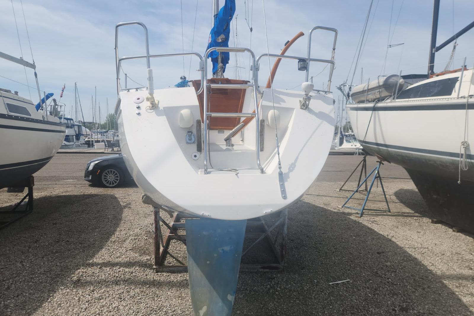 1990 Catalina Capri sailboat on dry dock, rear view with visible rudder and deck details.