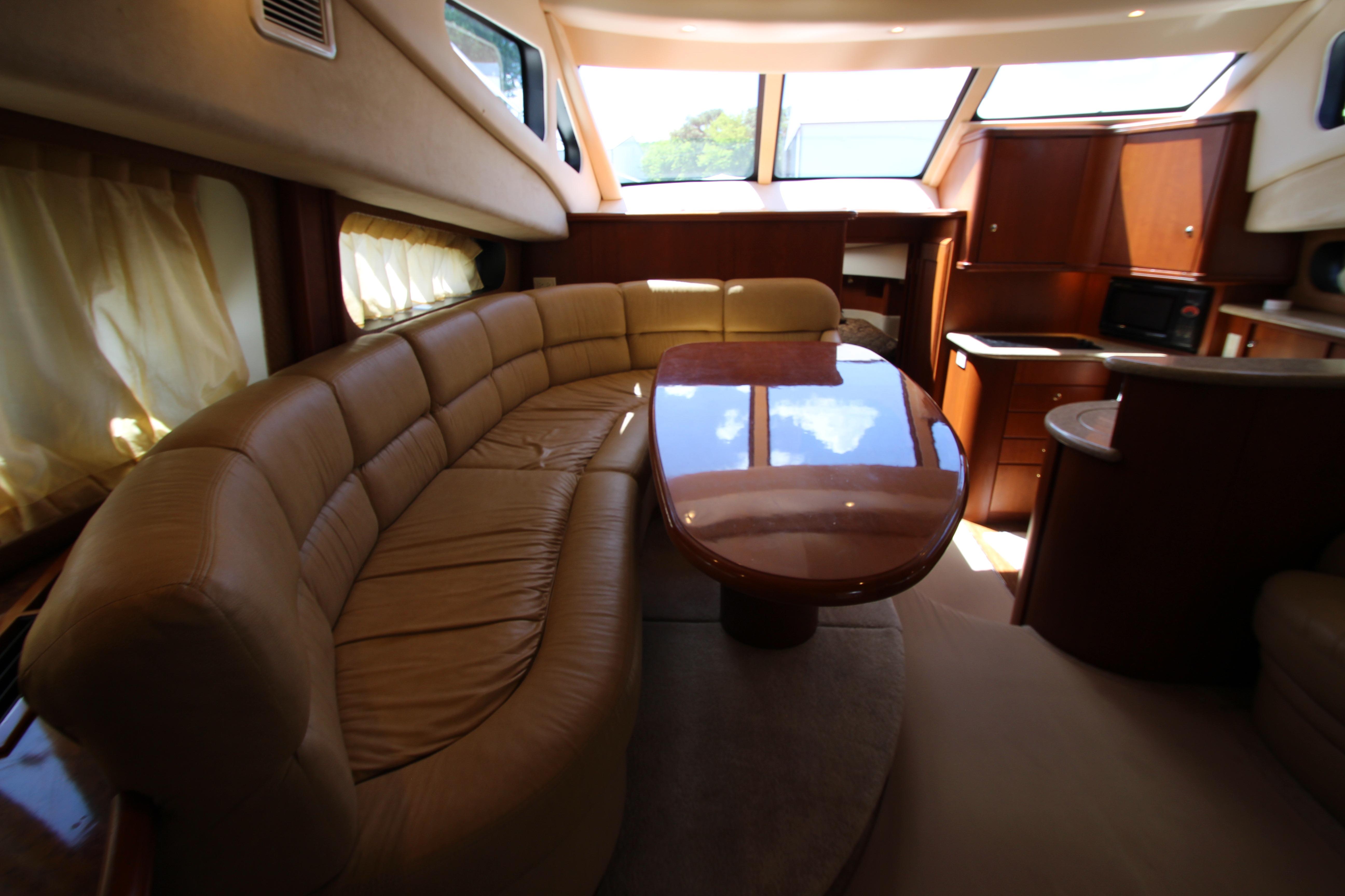 Luxurious interior of 2006 Silverton 38 Sport Bridge yacht with plush seating and elegant wood finishes.
