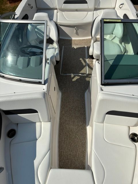 Interior view of a Chaparral 19 H2O Sport boat with white seating and carpeted flooring.