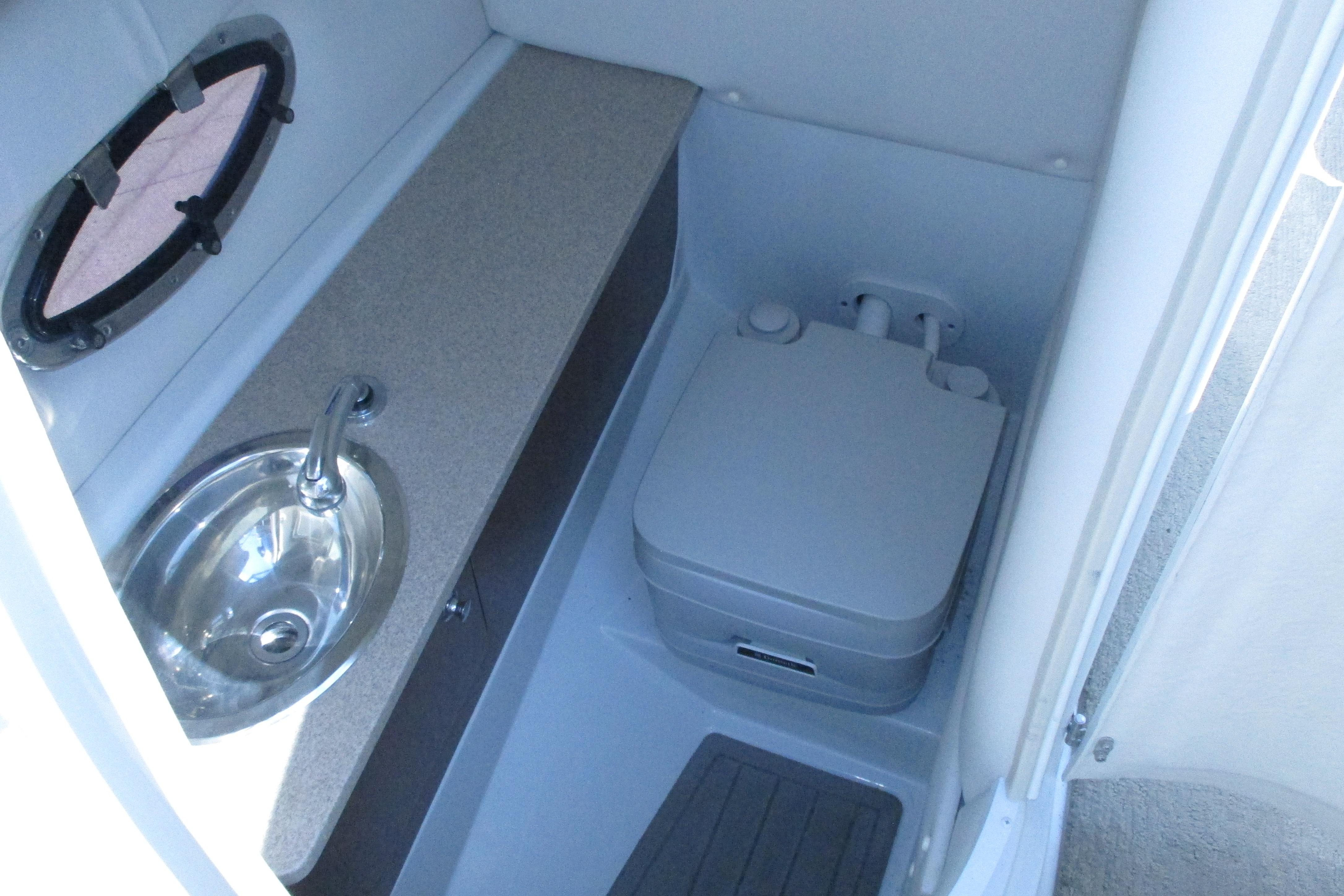 2017 Crownline 255 SS boat interior with sink and portable toilet.