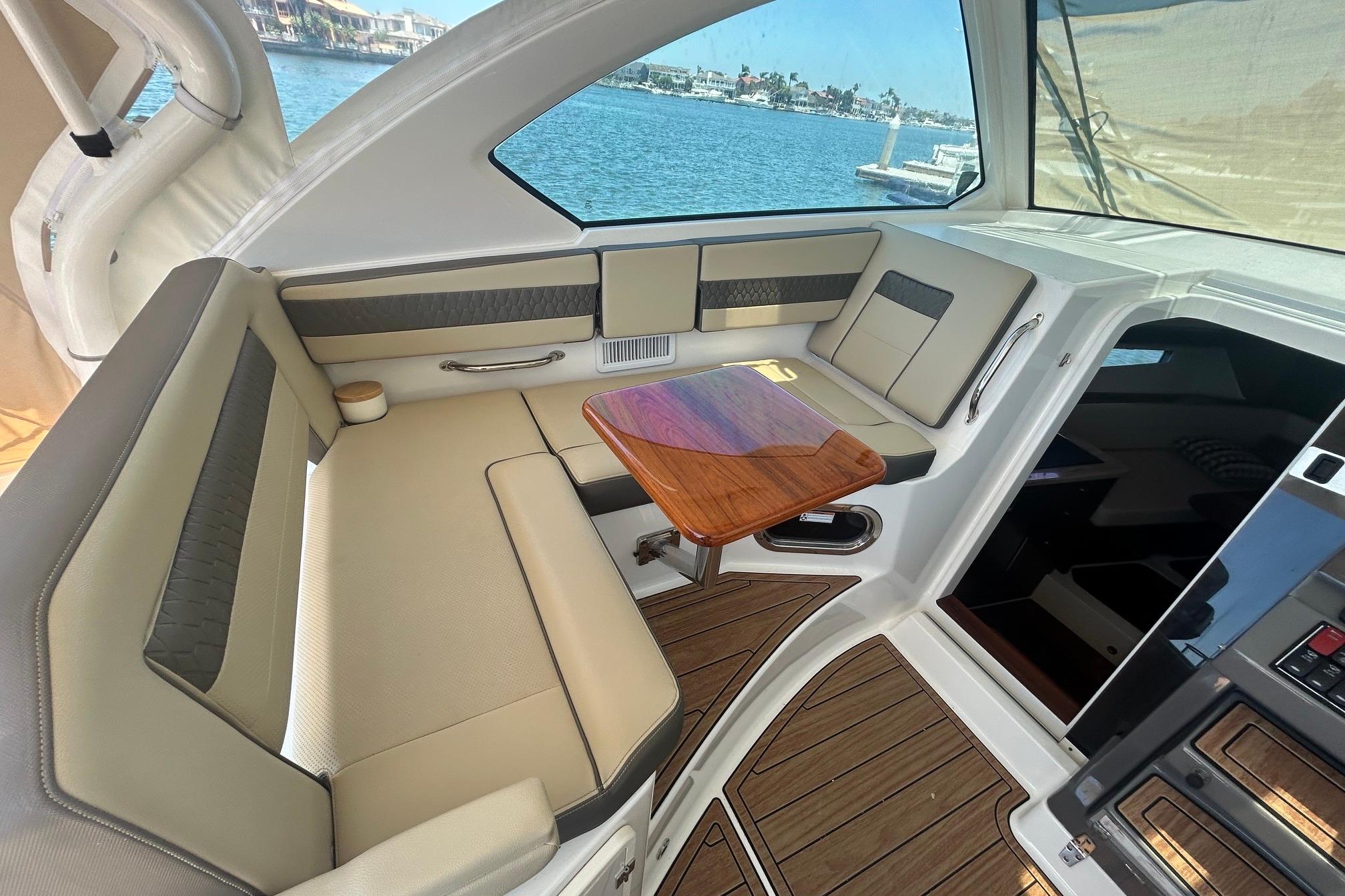Luxurious interior of 2019 Pursuit OS 355 Offshore yacht with elegant seating and wooden table.