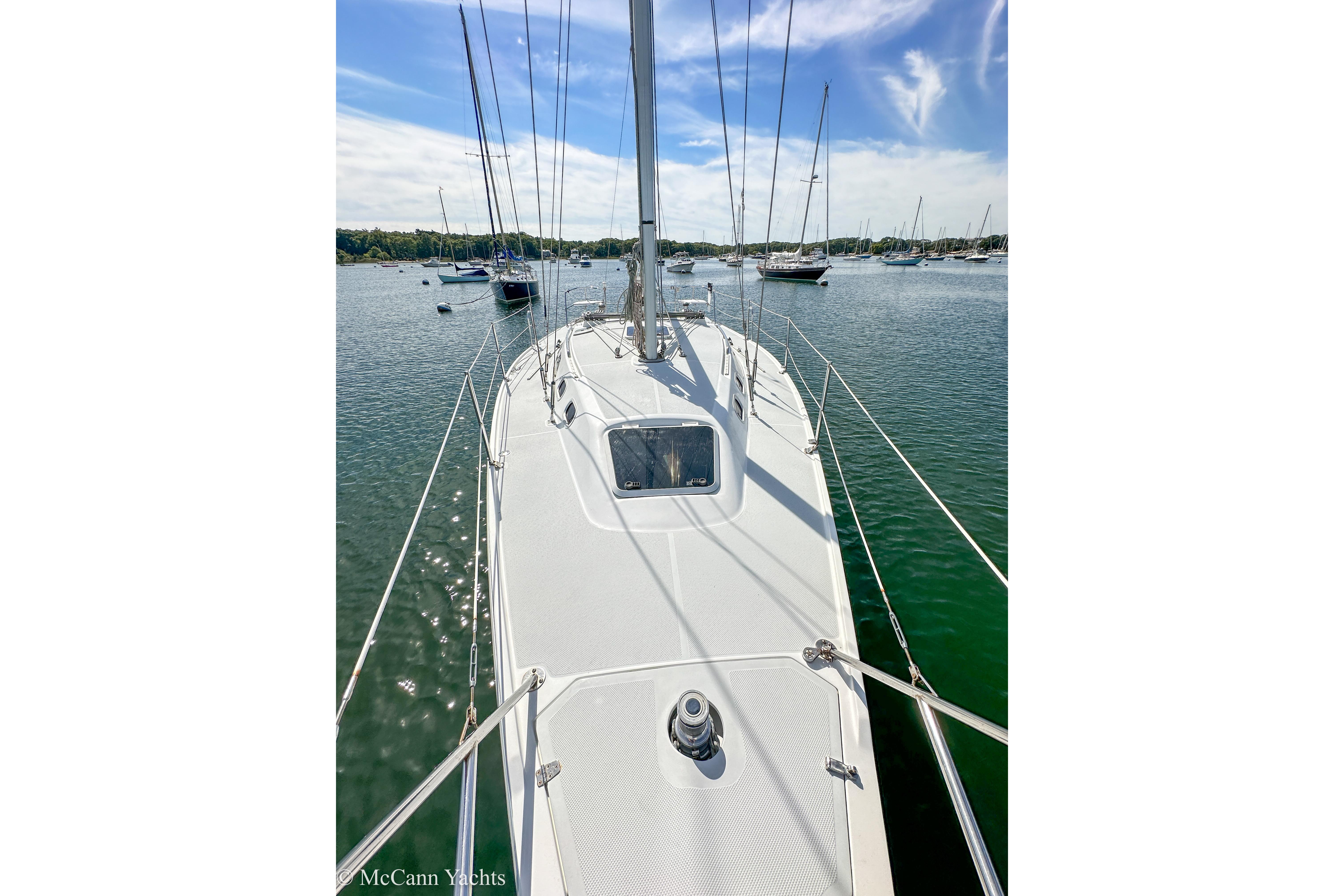 Sailboat Catalina 320, 2003 model, docked in a serene marina under a blue sky.