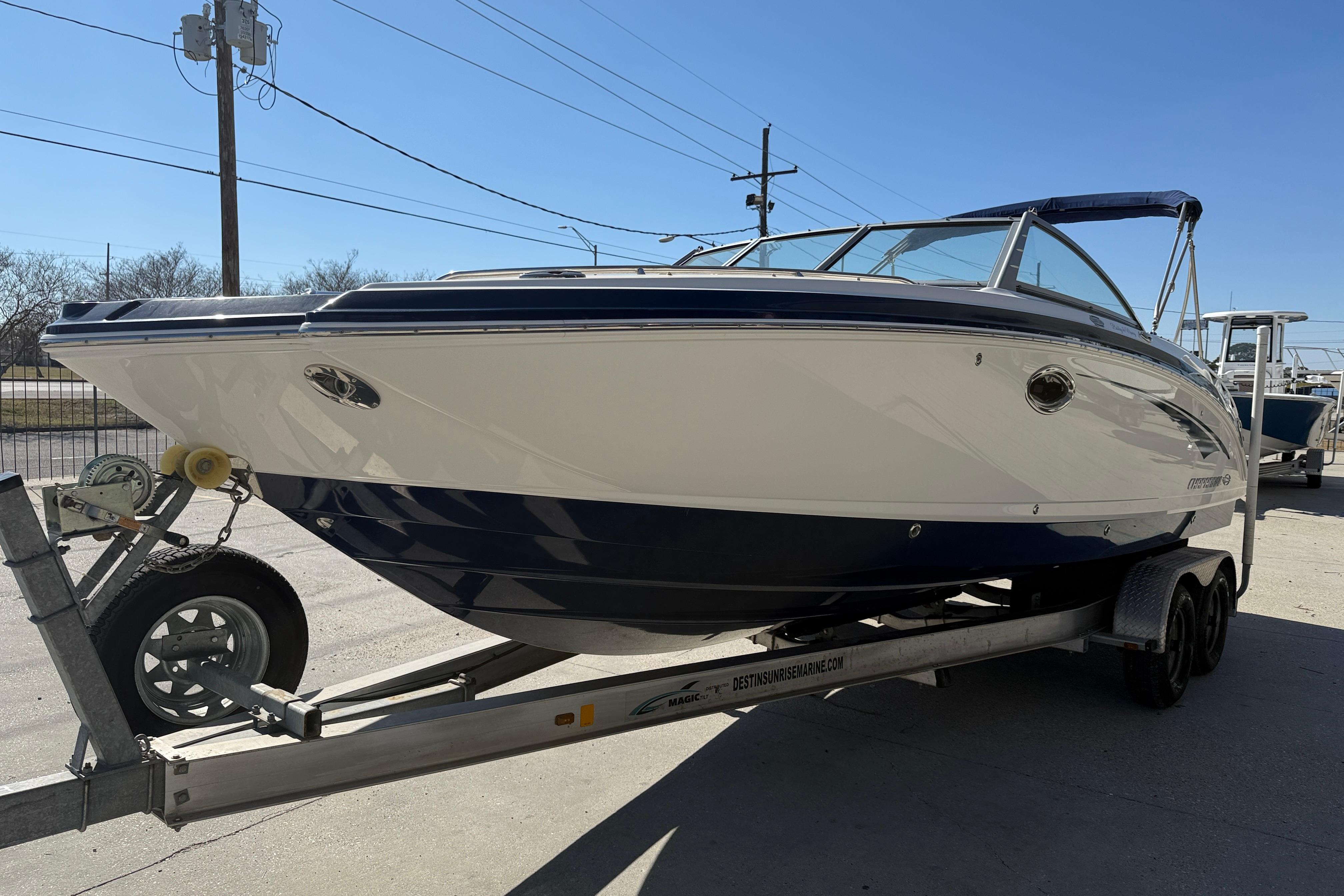 2014 Chaparral 264 Sunesta boat on trailer, parked outdoors under clear sky.