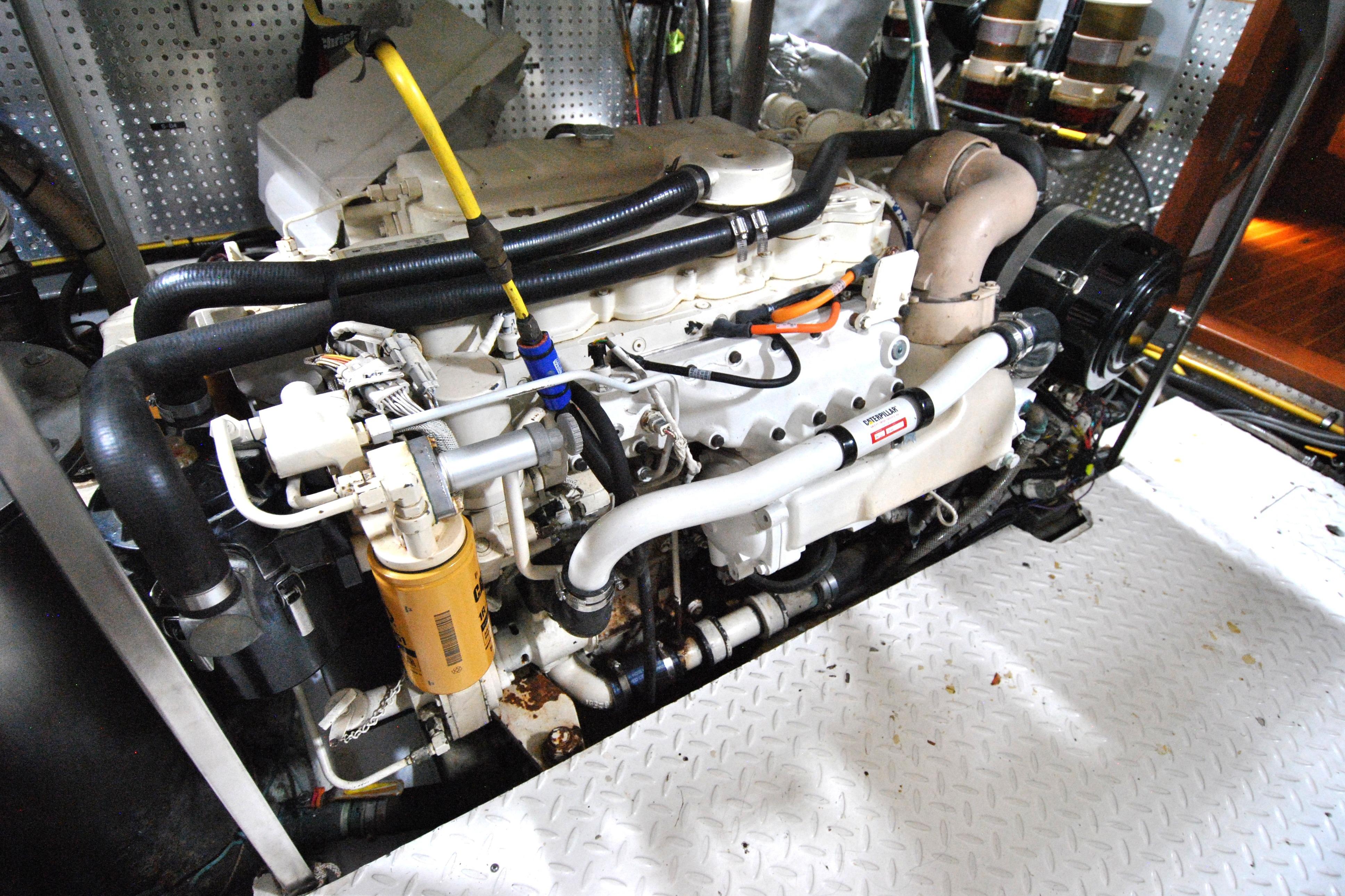 Engine room of a 2002 Grand Alaskan Cockpit Motor Yacht, showcasing detailed machinery.