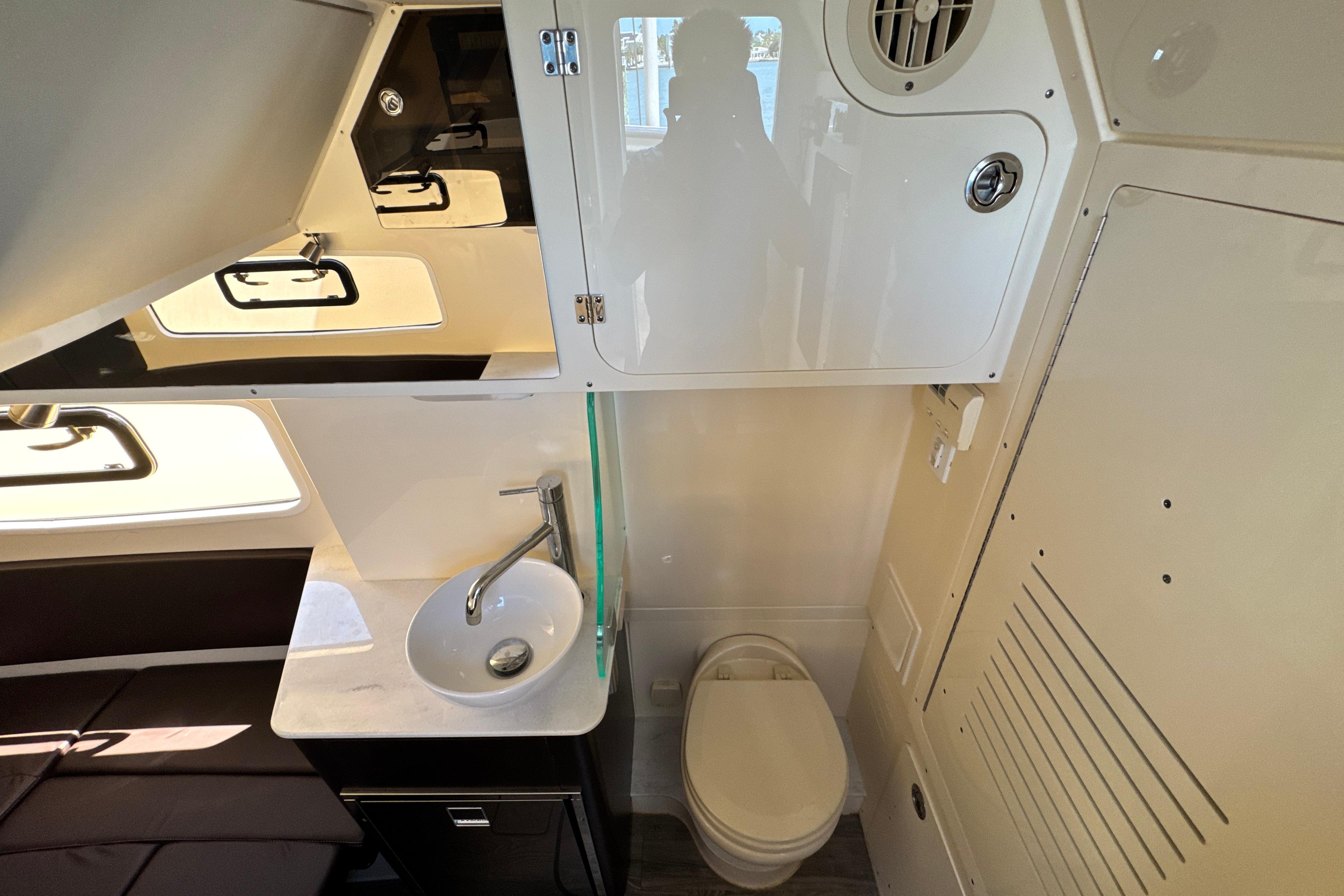 2018 Scout 355 LXF boat interior with sink, toilet, and storage cabinets.