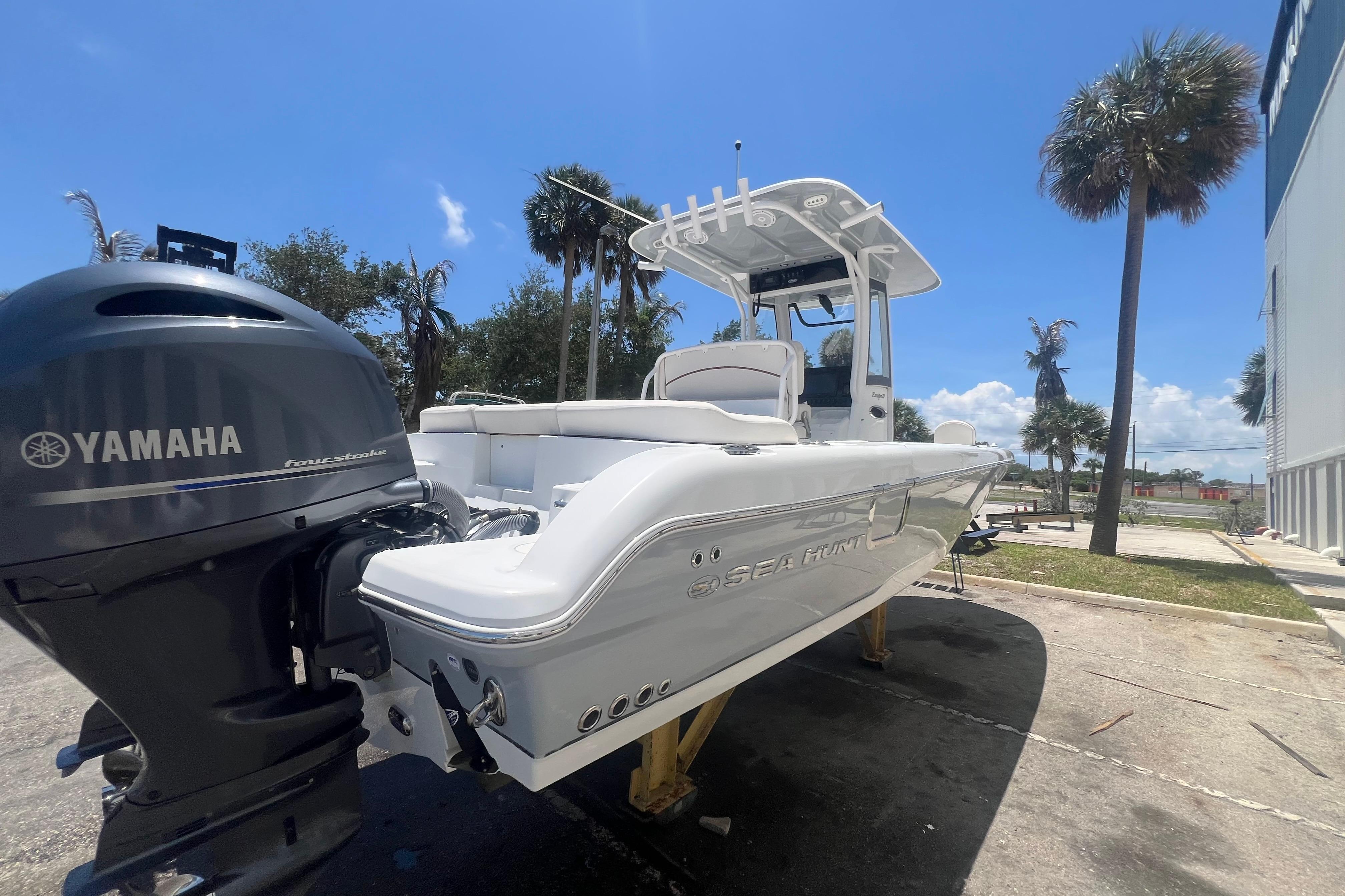 2022 Sea Hunt Escape 27 boat with Yamaha engine, parked outdoors under clear blue sky.