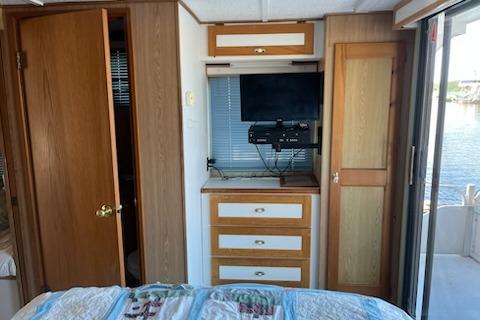 Interior of 1994 PlayCraft 5215 with TV, drawers, and water view.