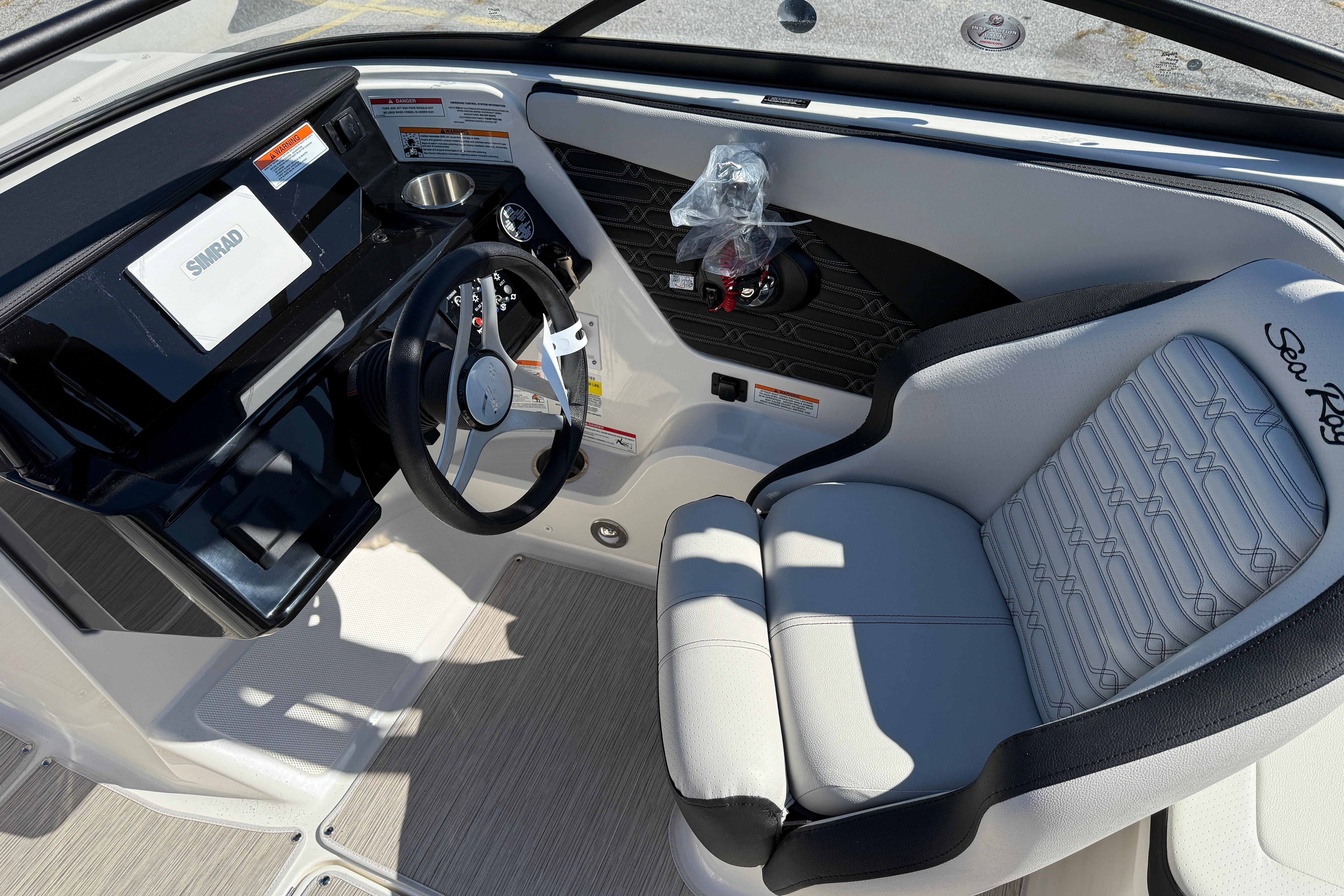 2026 Sea Ray SPX 210 boat interior with steering wheel and Simrad display.