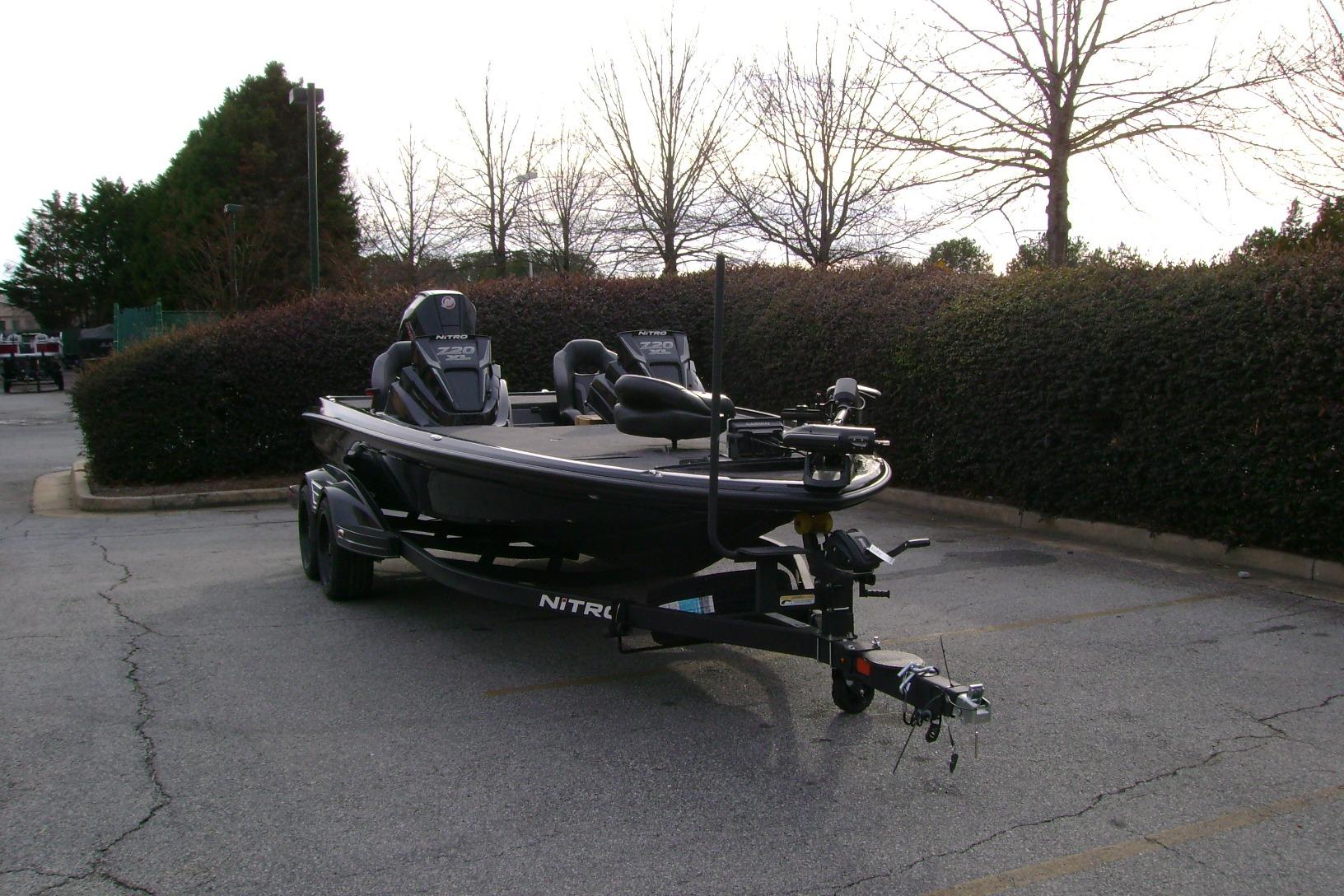 2026 Nitro Z20 XL Pro boat parked in a lot, surrounded by trees.