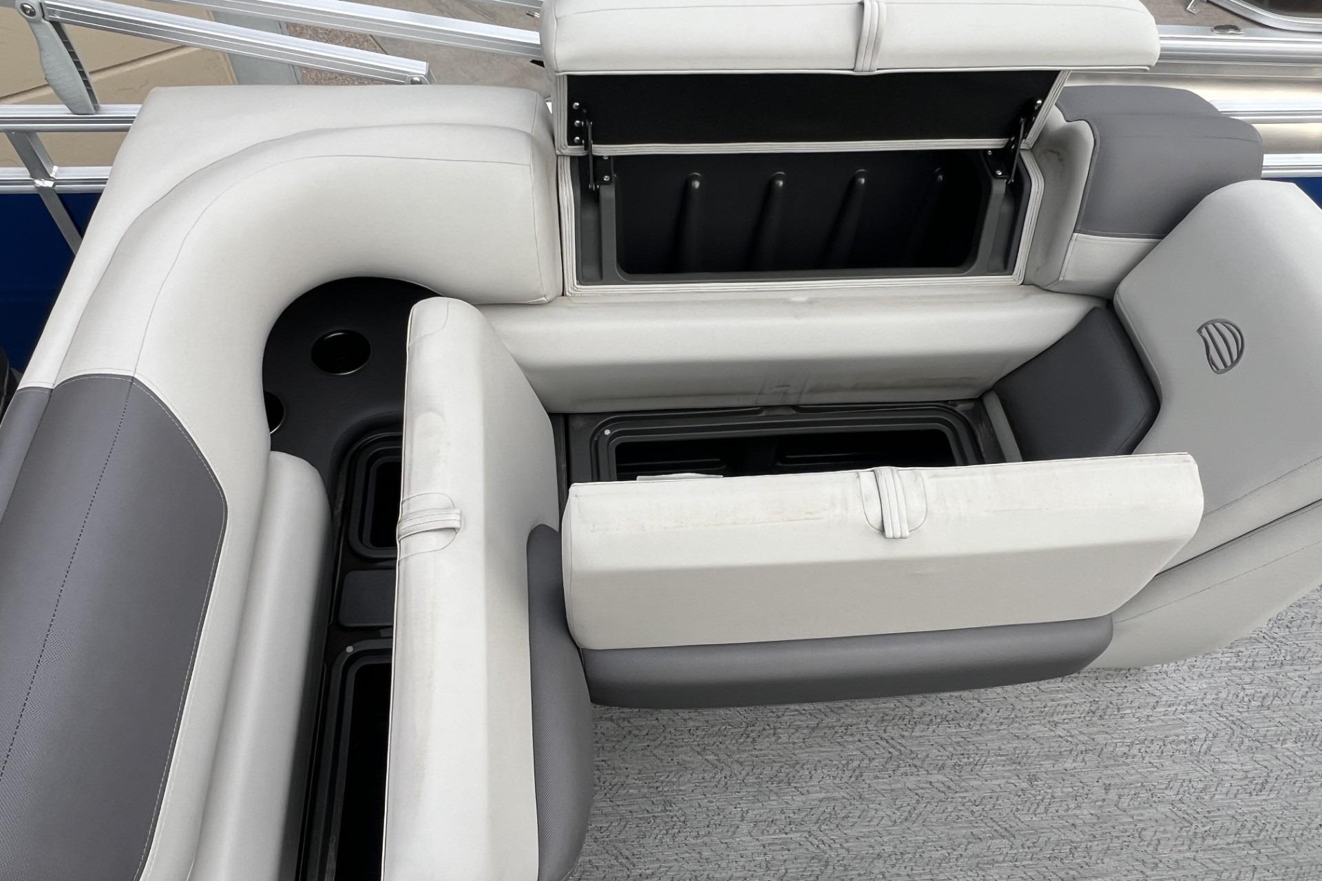 2026 Sun Tracker Fishin' Barge 20 DLX interior seating with storage compartments open.