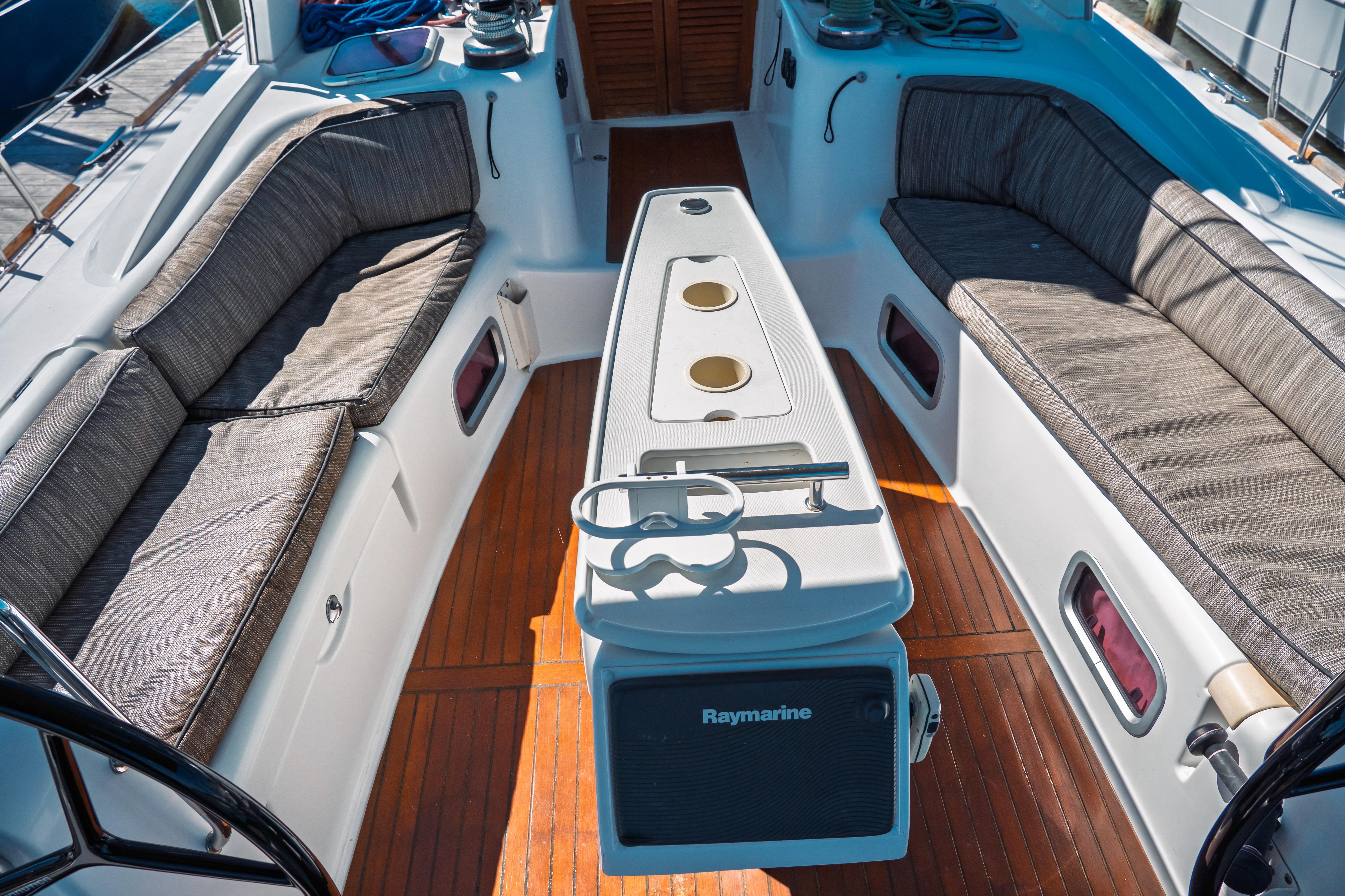 Cockpit of 2011 Beneteau Oceanis 50 sailboat with cushioned seating and Raymarine equipment.