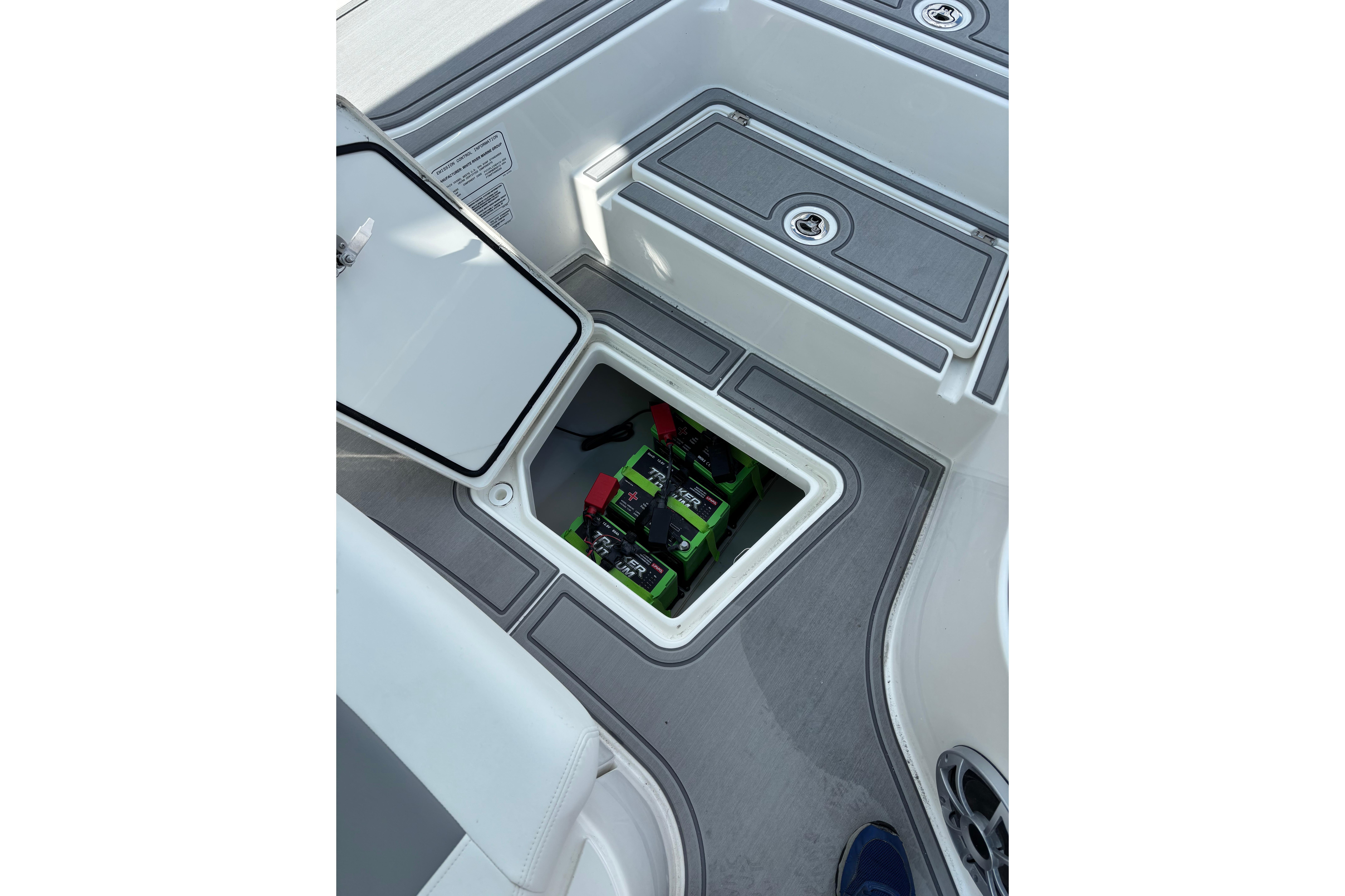 Open hatch on 2026 Mako 24 APEX boat revealing battery compartment.