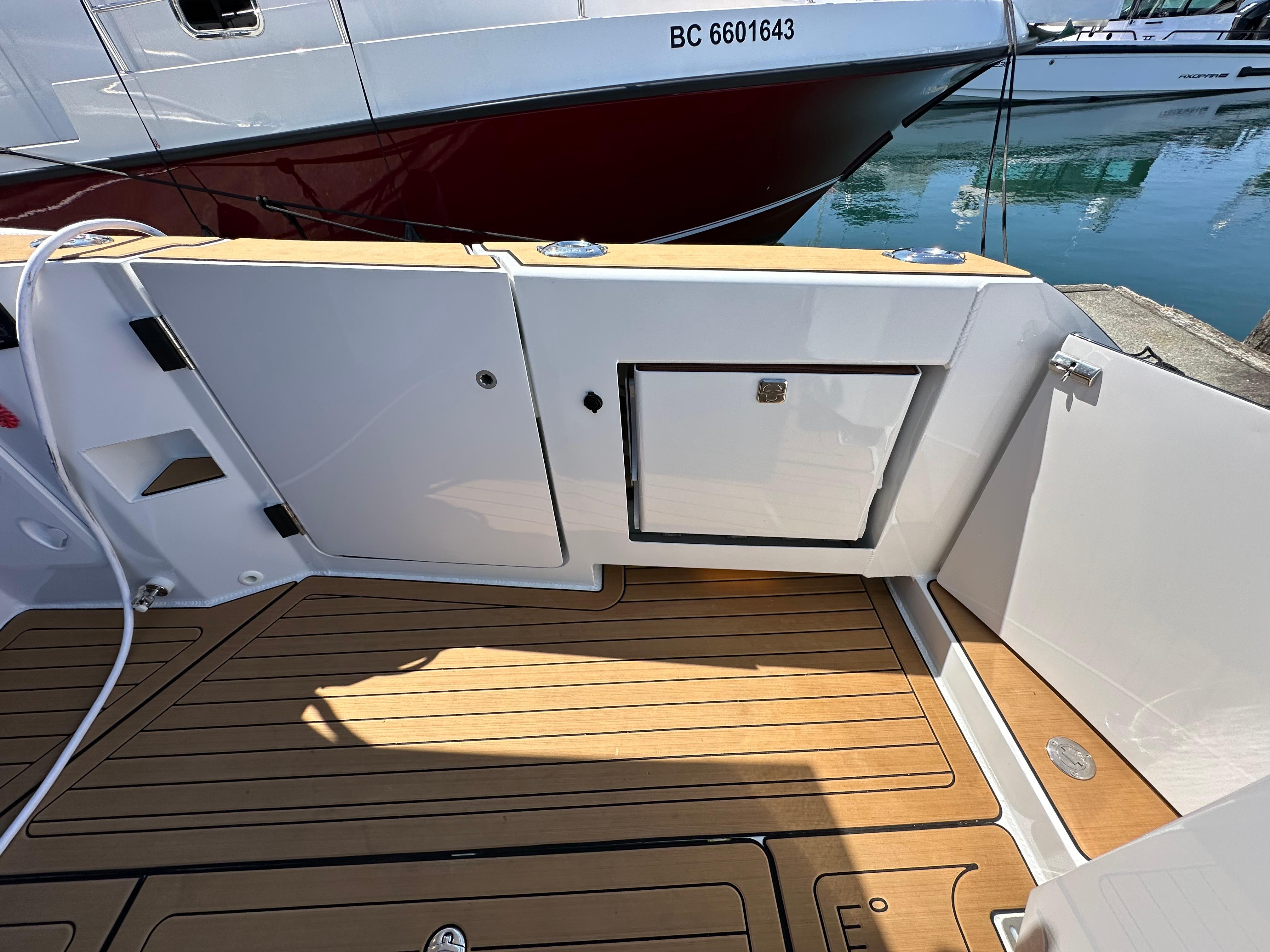 2024 Herley 11 Explorer boat deck with teak flooring and storage compartments.