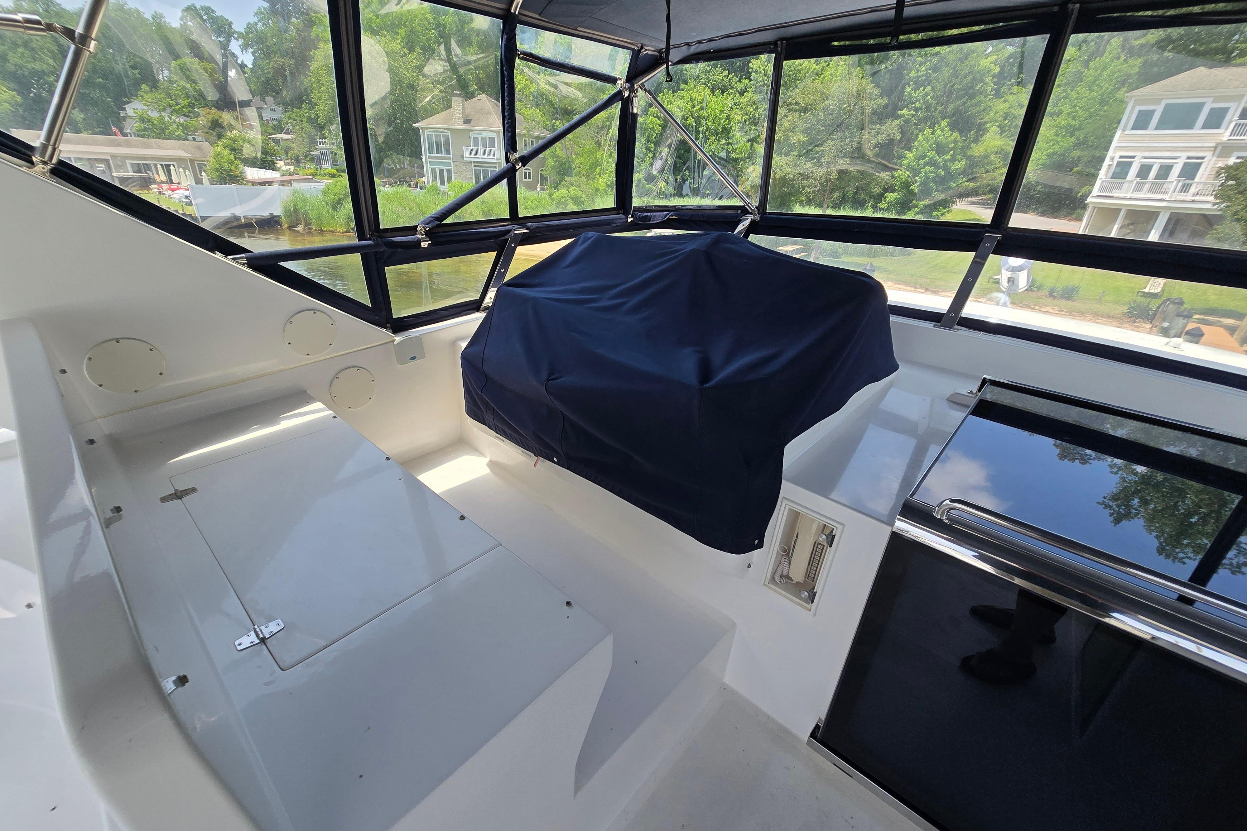 Interior view of 2004 Grand Harbour 58 yacht with covered seating and large windows.