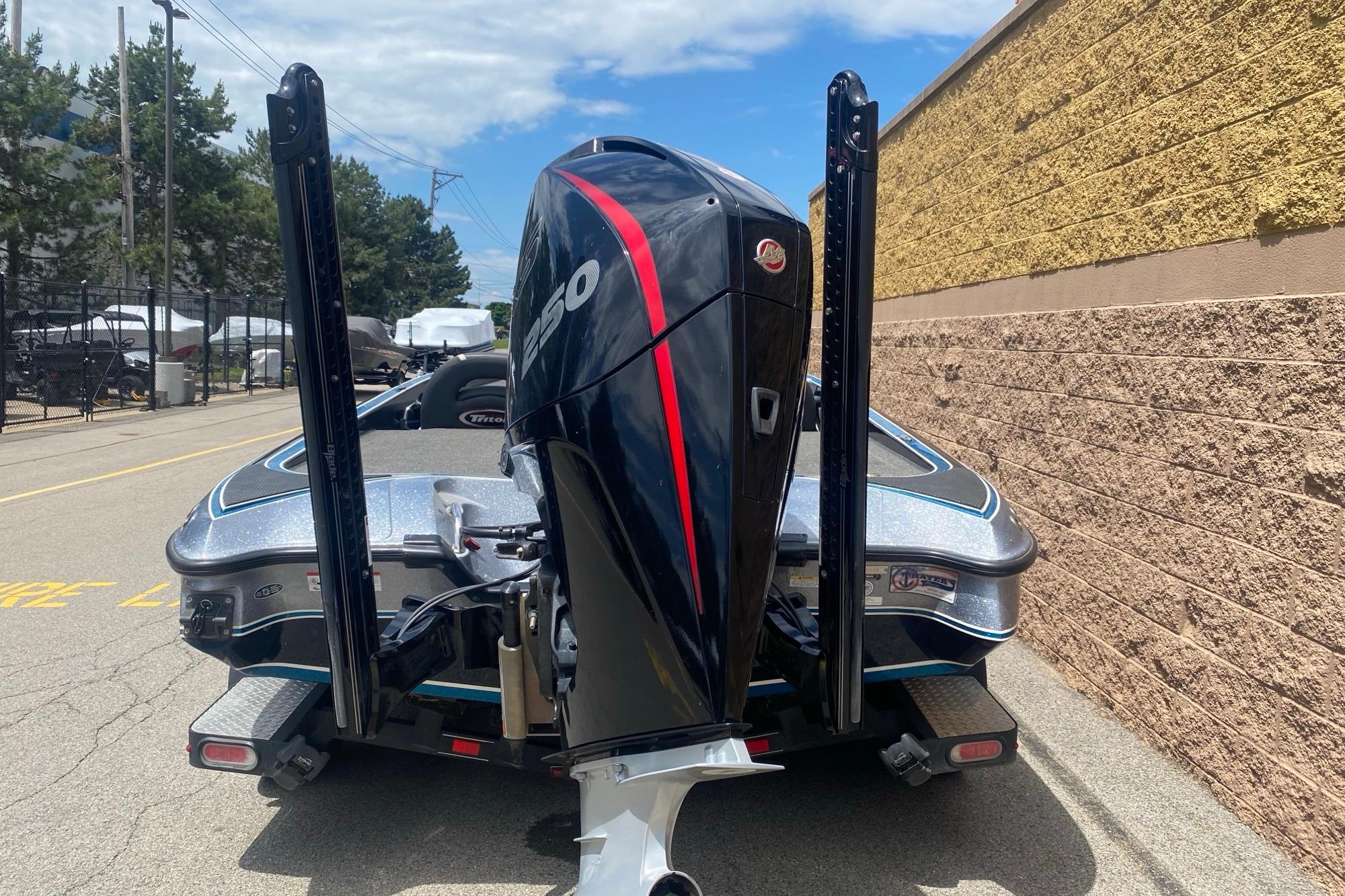2020 Triton 20 TrX Patriot boat with powerful outboard motor, parked outdoors.