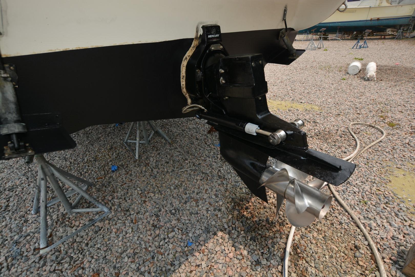 1999 Rinker 270 Fiesta Vee boat propeller and outdrive on gravel.