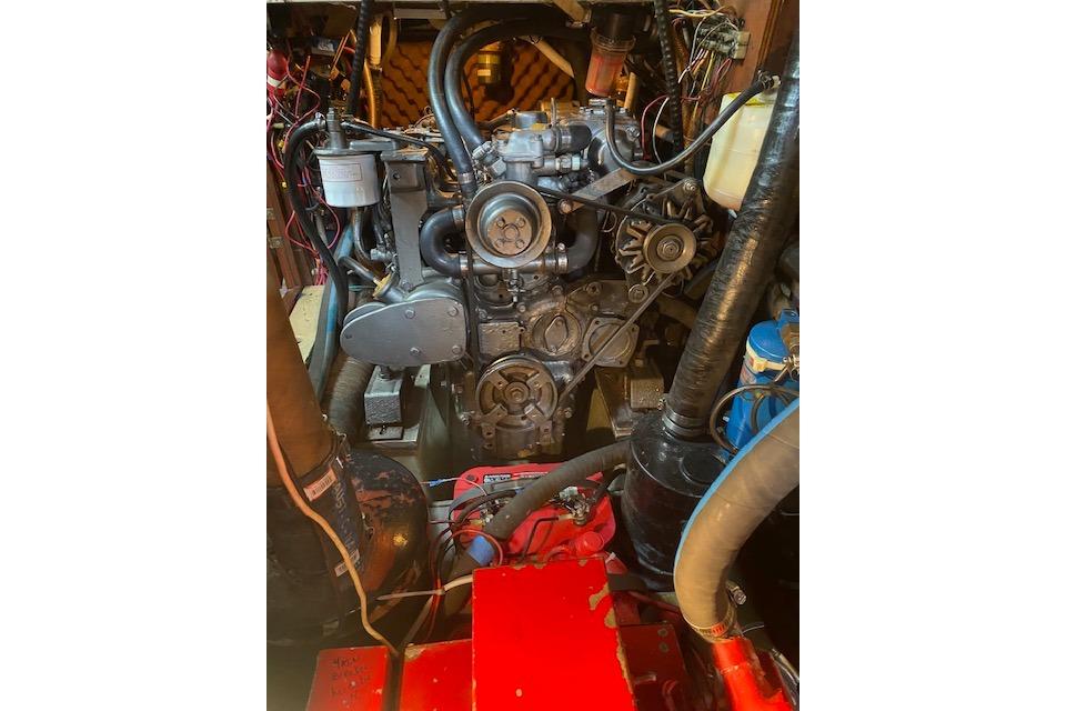 Engine compartment of a 1982 Endeavour 40 sailboat, showcasing mechanical components and wiring.