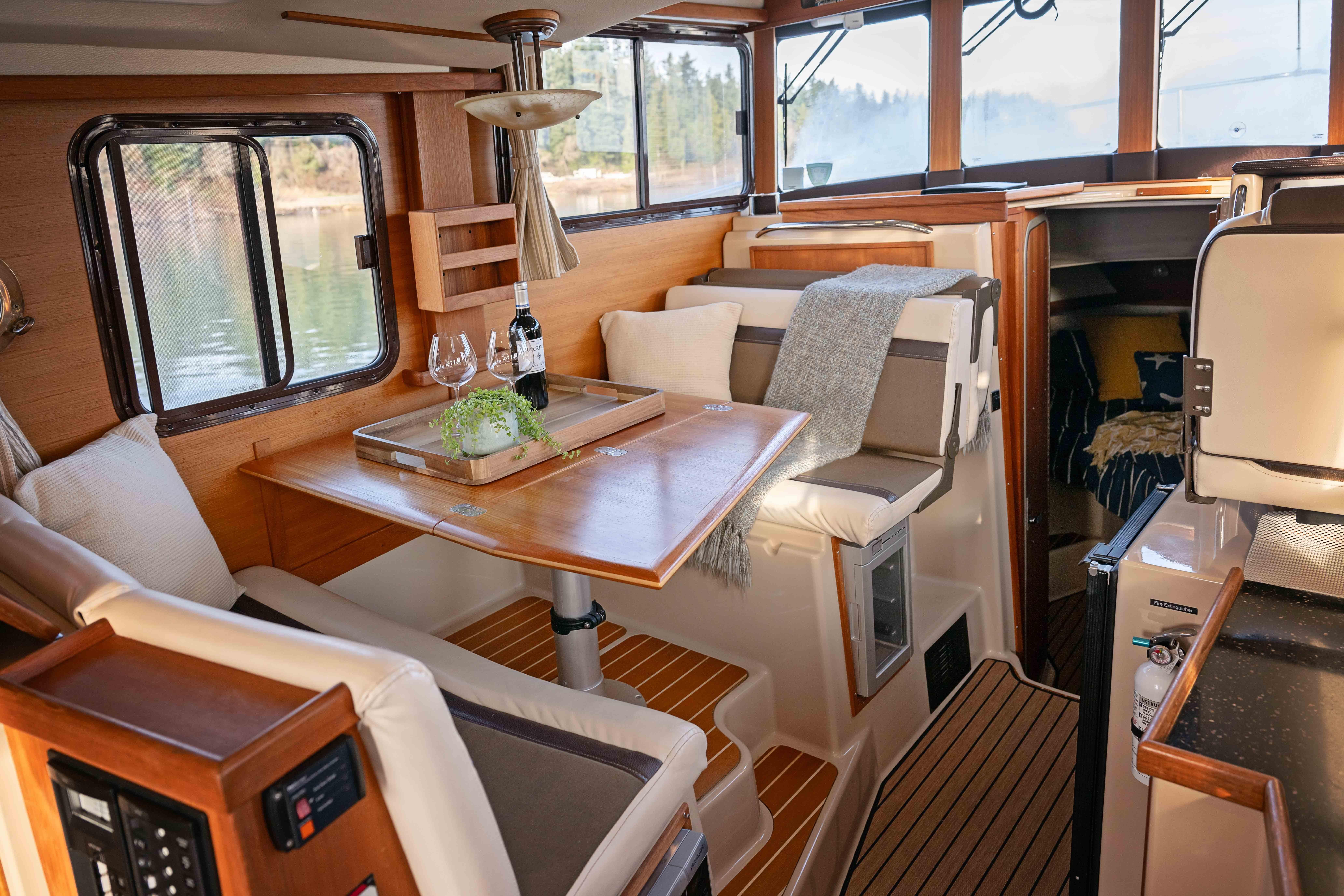 Cozy interior of 2014 Ranger Tug R-31 CB with dining area and scenic window views.