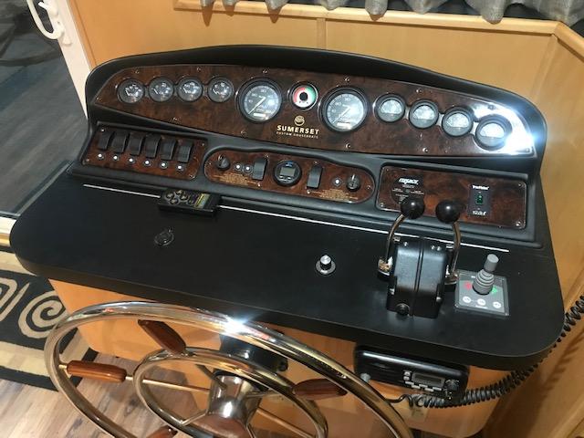 Control panel of a 2002 Sumerset Houseboat with steering wheel and gauges.