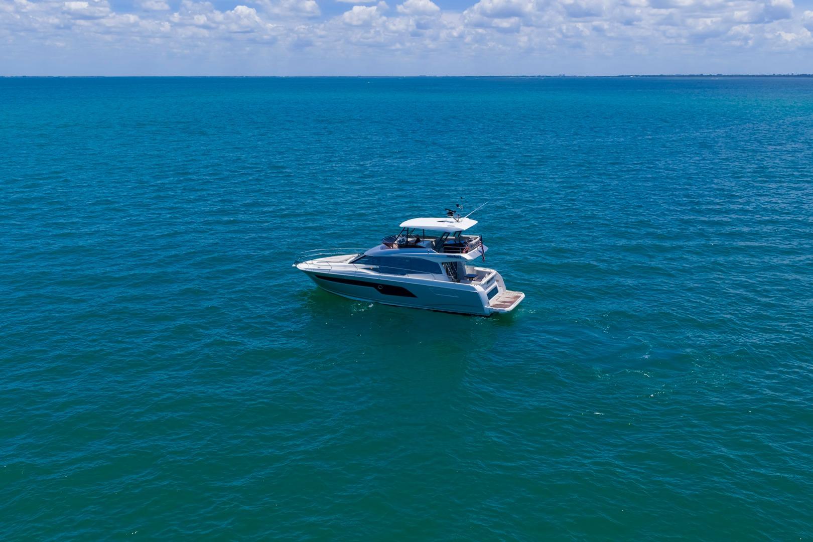 Luxury 2022 Prestige 520 yacht cruising on clear blue ocean waters.