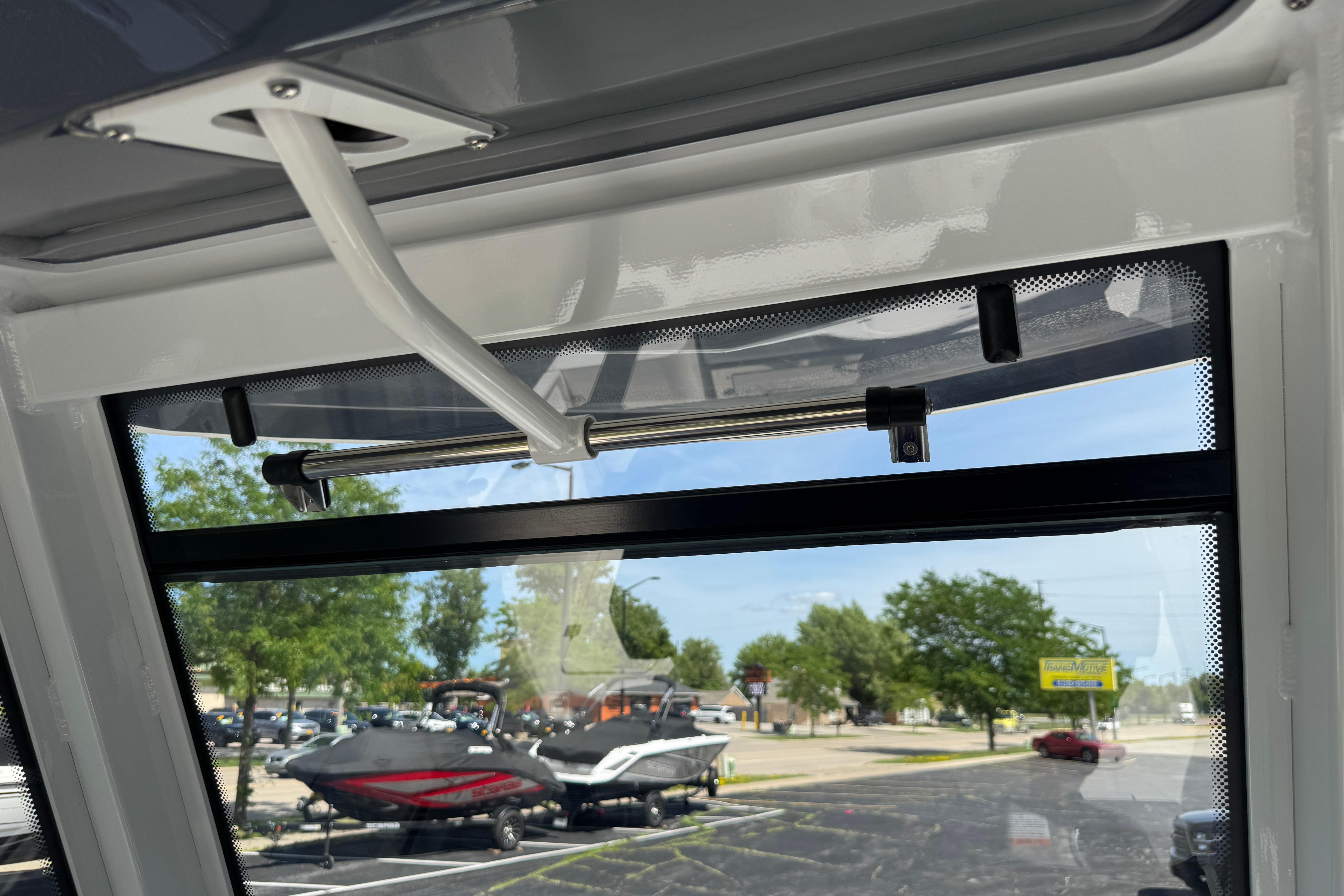 Interior view of 2026 Robalo R250 Center Console boat window and latch mechanism.