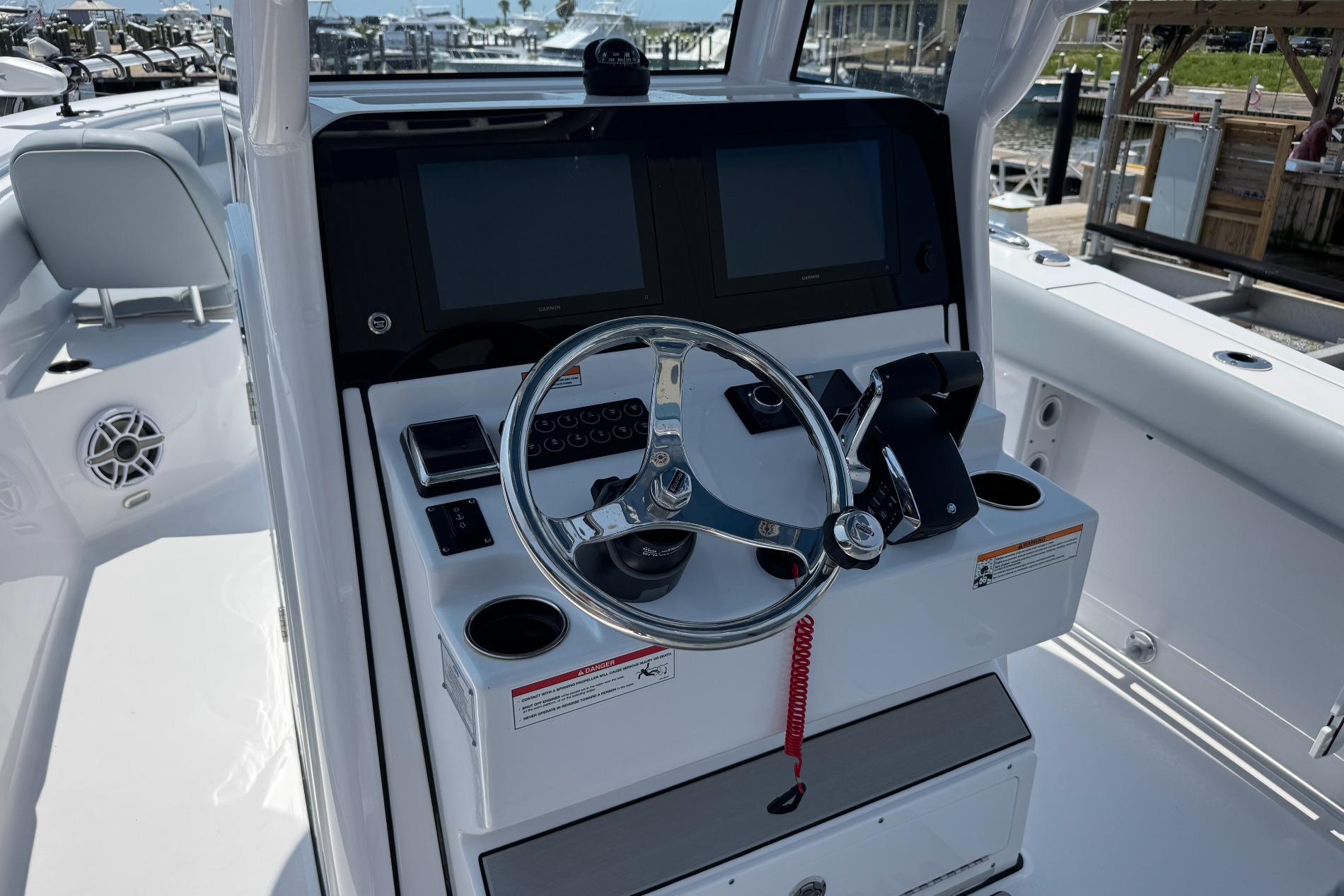2026 Sportsman Open 262 Center Console boat helm with dual screens and steering wheel.