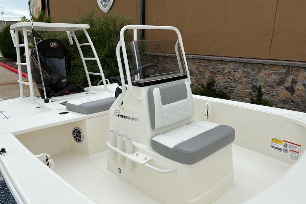 2026 Mako 18 Pro Skiff boat with seating and outboard motor, docked outdoors.