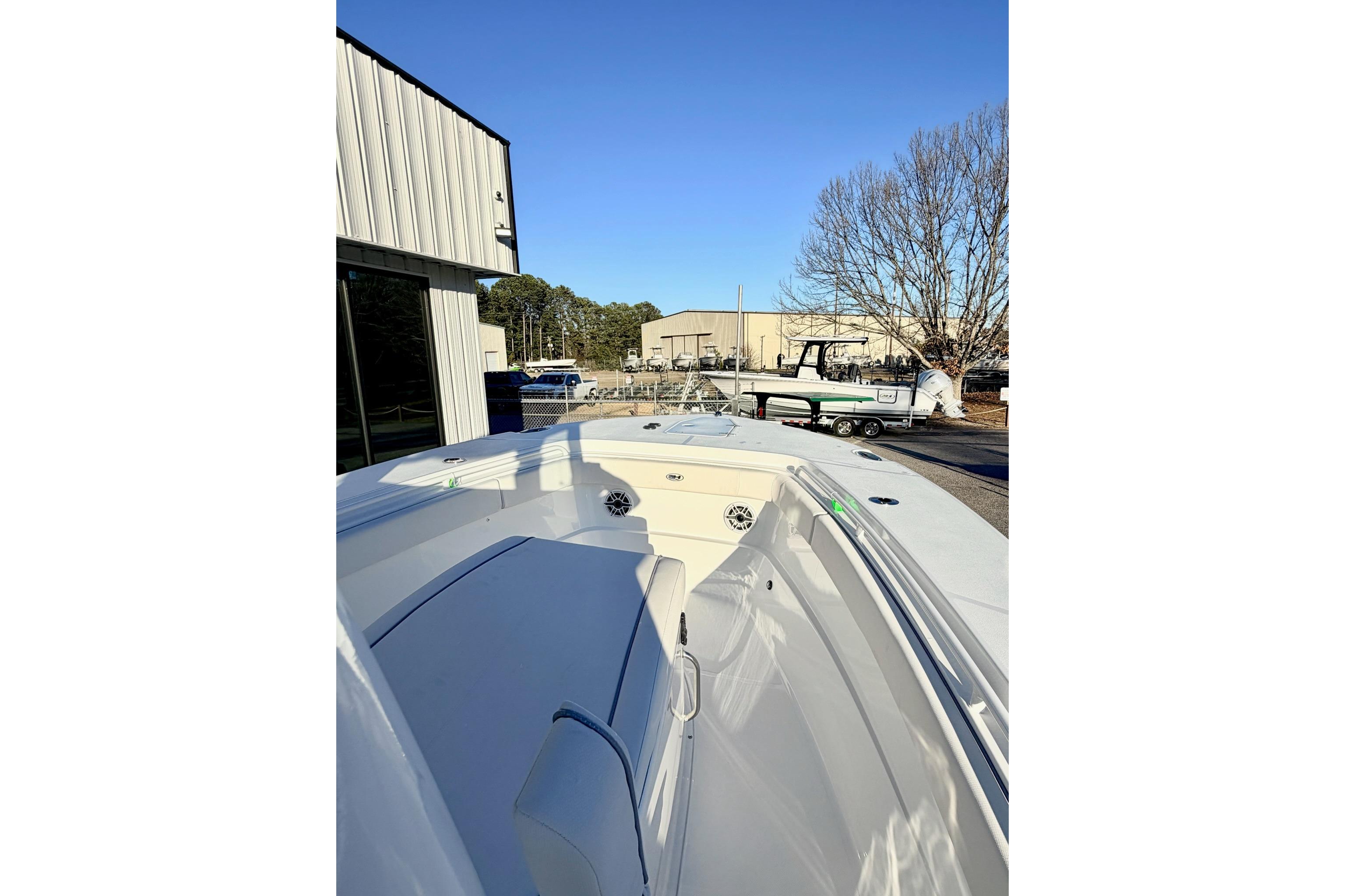 2026 Sea Hunt Ultra 275 Coffin Box boat at a marina under clear blue sky.