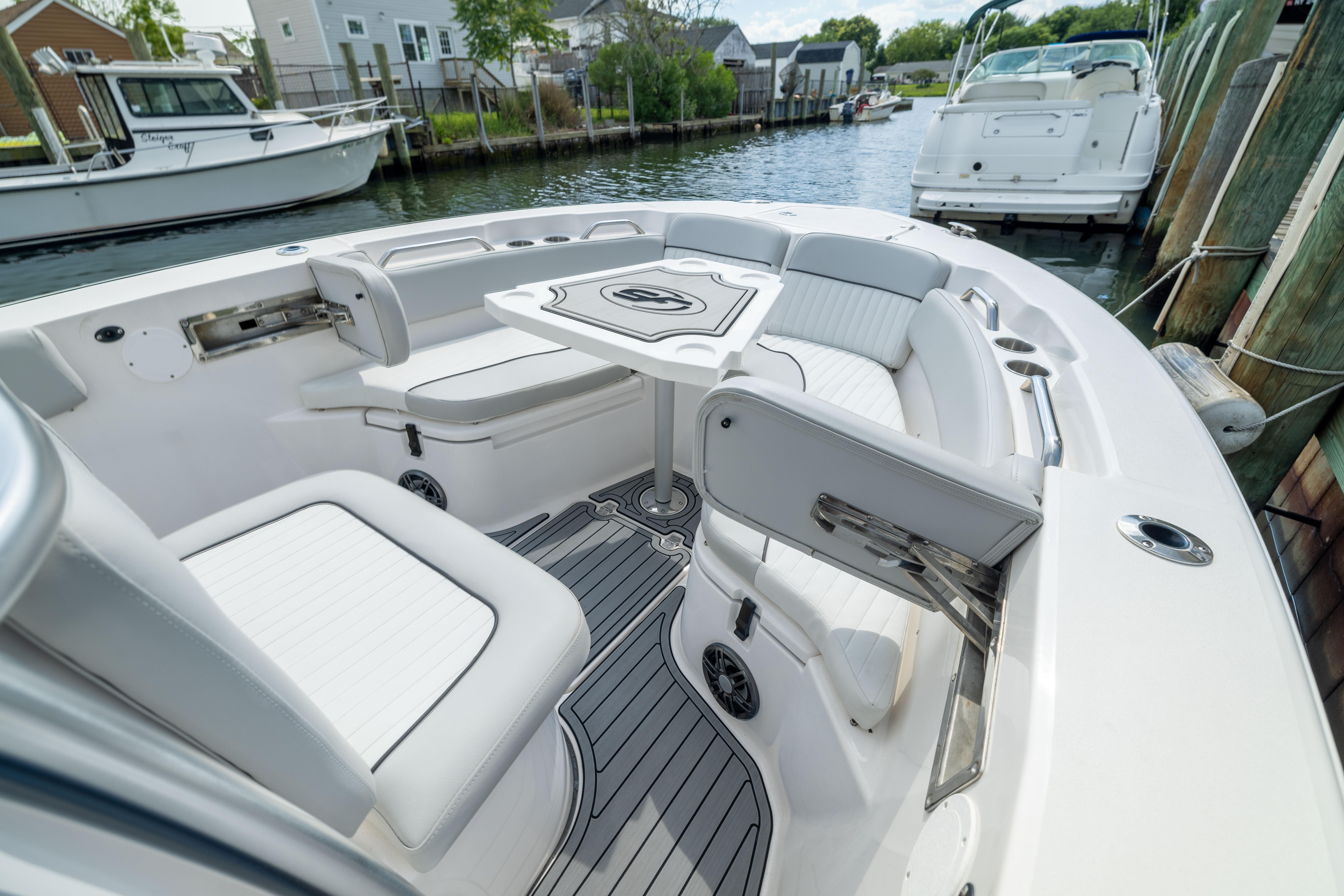 2023 Sea Fox 228 Commander boat interior with seating and table, docked by the water.