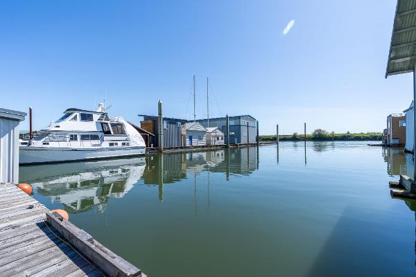 Calm marina view with a Custom 1985 Larson Boathouse and docked yacht.
