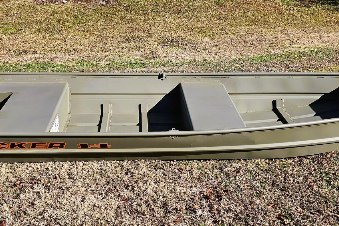 2026 Tracker Grizzly 14 Jon boat on grassy terrain, showcasing its sturdy design.
