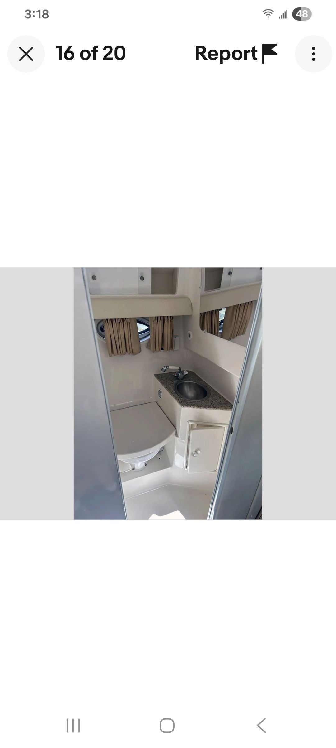 Interior of a Monterey 290 Cruiser with a sink and curtains.