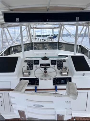 1986 Egg Harbor 60 Sportfisherman helm with controls and steering wheel, marina view.