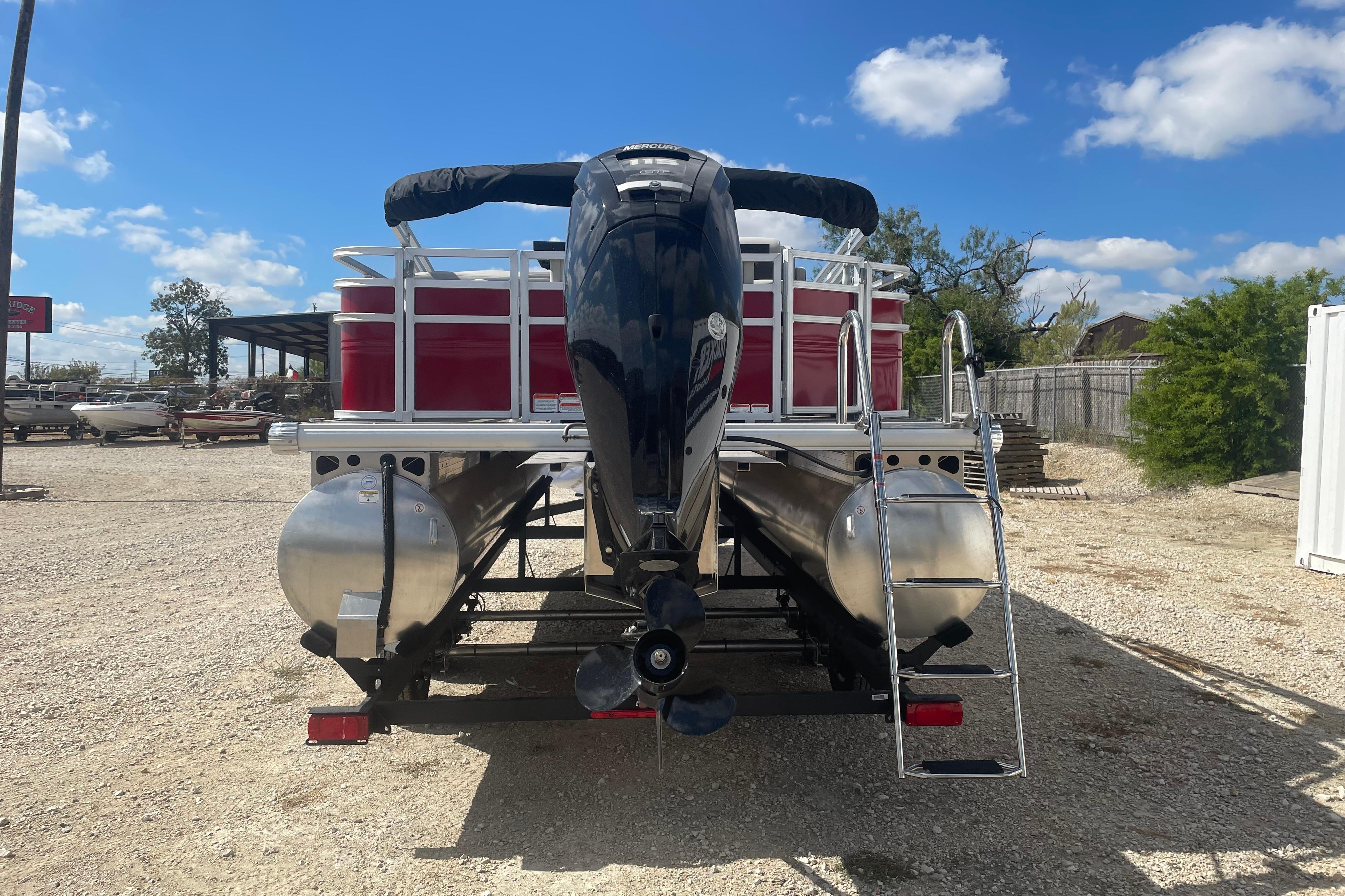 2026 Sun Tracker Fishin' Barge 22 DLX pontoon boat with outboard motor and ladder.