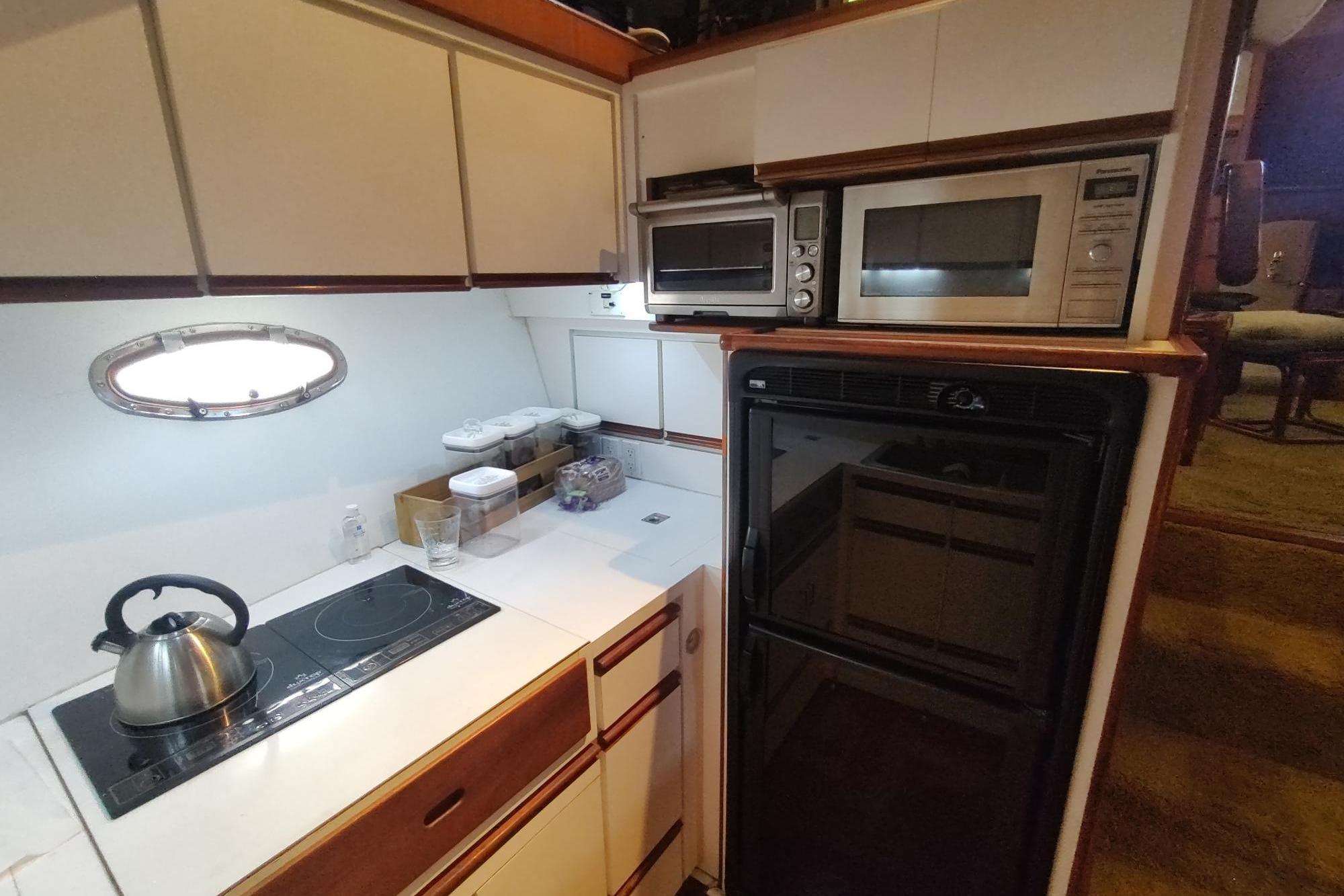 Compact kitchen in a 1989 Hyatt Double Cabin Motoryacht with modern appliances and sleek design.