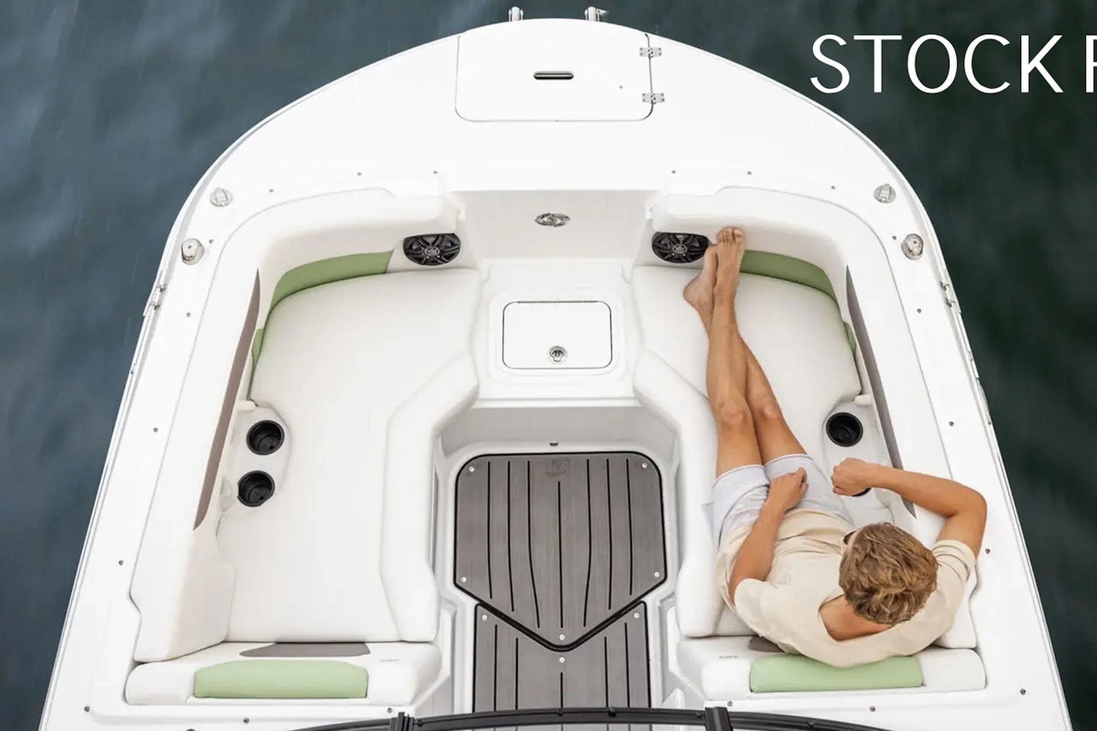2026 Hurricane SunDeck 2050 OB boat interior with person relaxing on white seating.