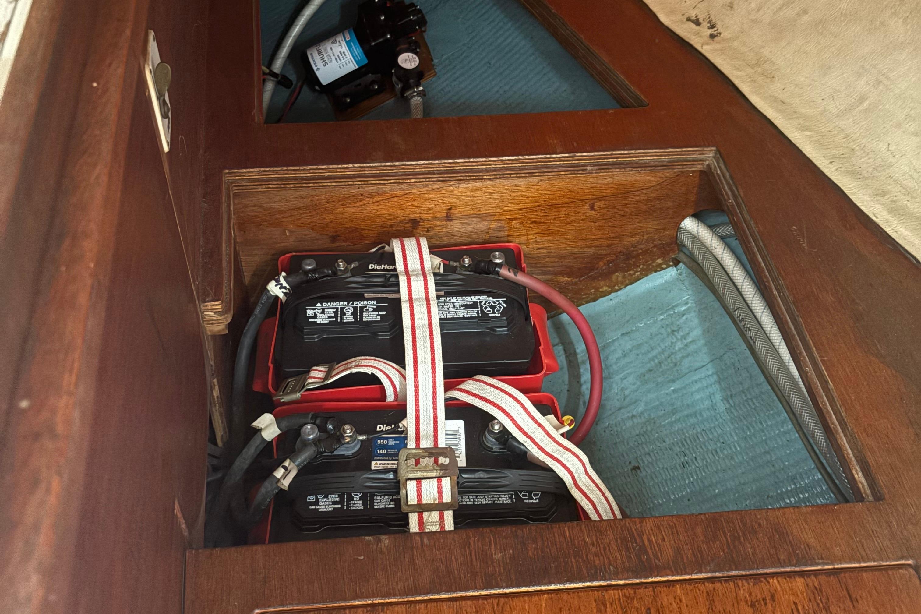 Battery compartment of a 1981 Sabre 31 sailboat, featuring secured DieHard batteries.
