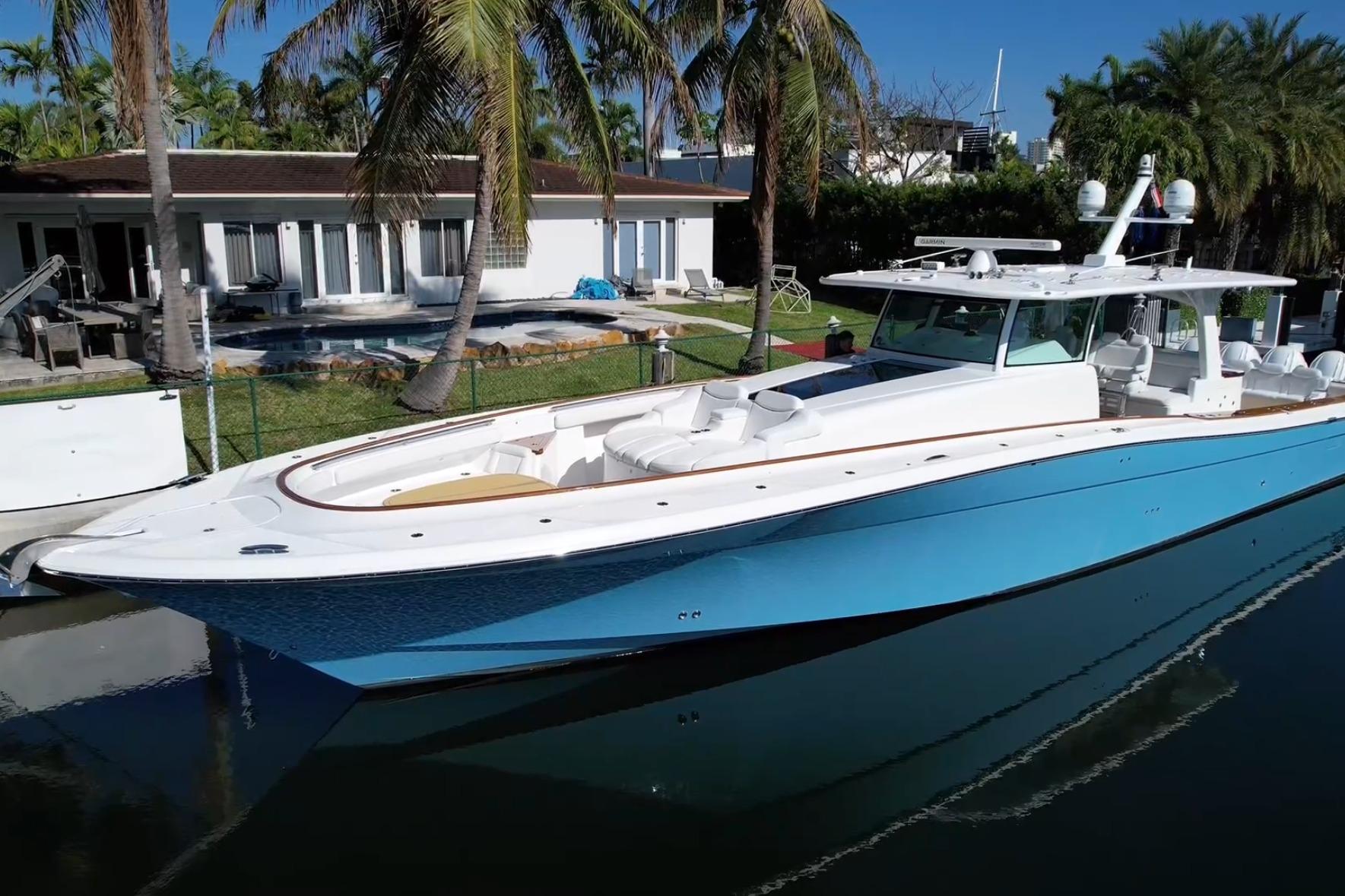 2021 HCB 65 Estrella yacht docked by a tropical waterfront home.